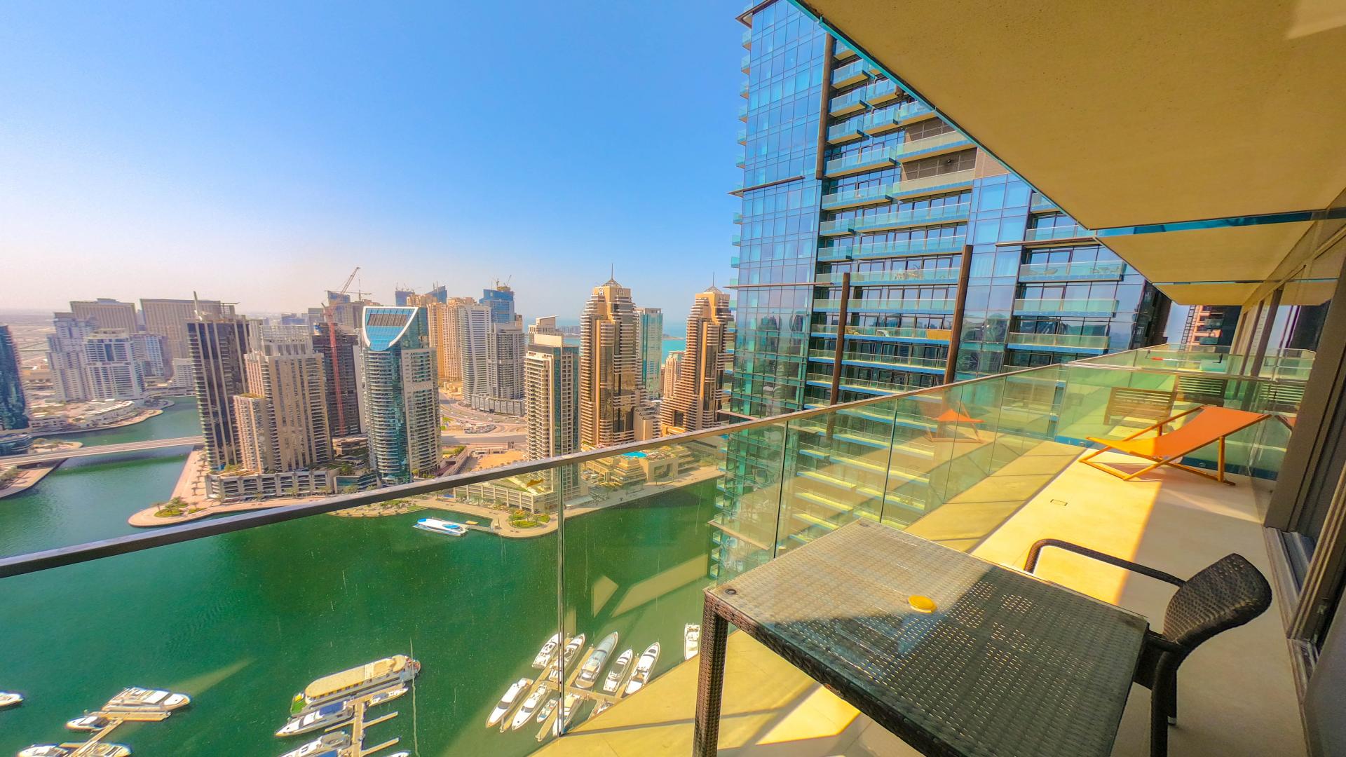 Modern dining area with glass table and lion artwork in Dubai Marina apartment