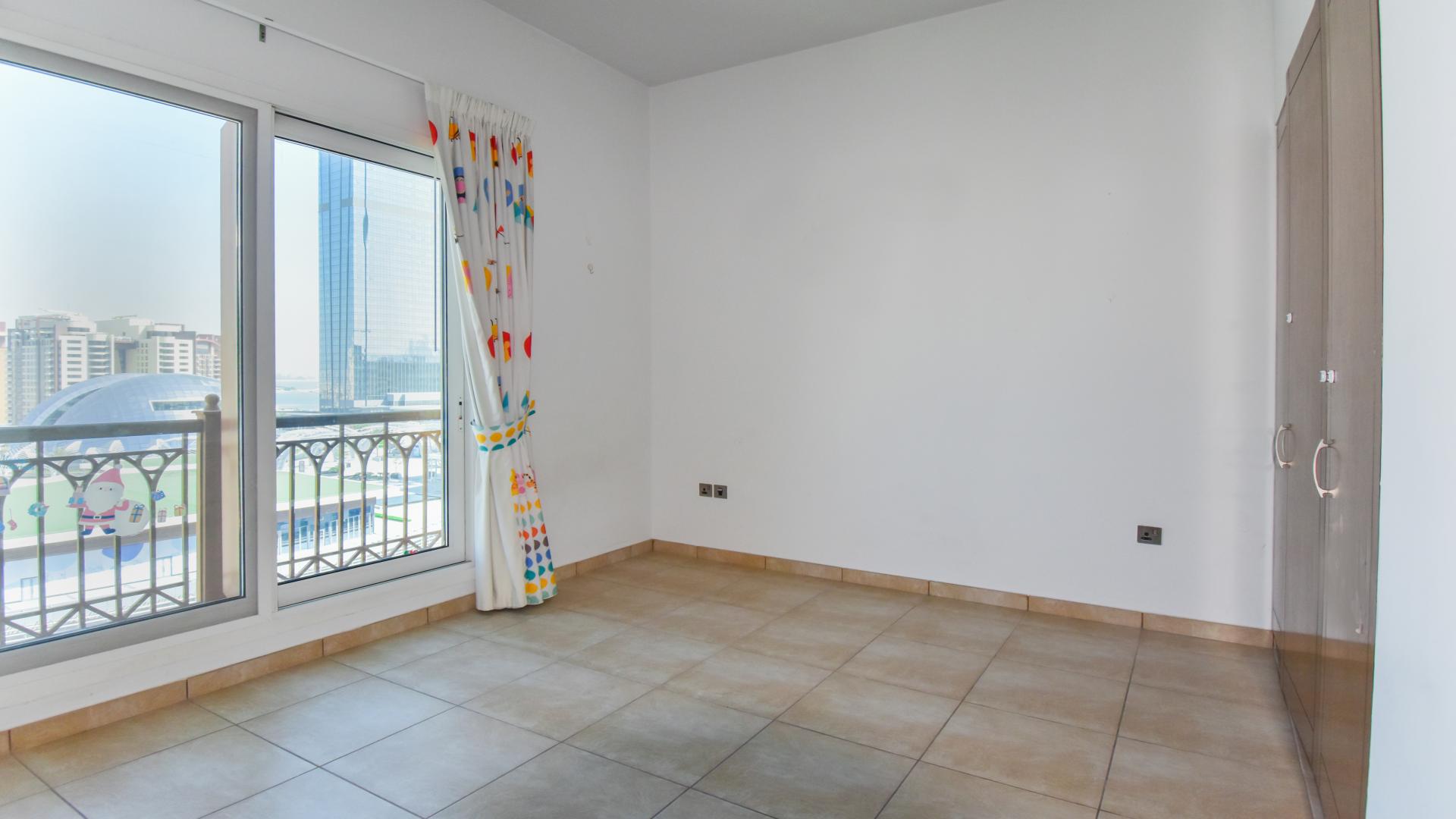 Vacant living room in Marina Residence apartment, Palm Jumeirah, with balcony view