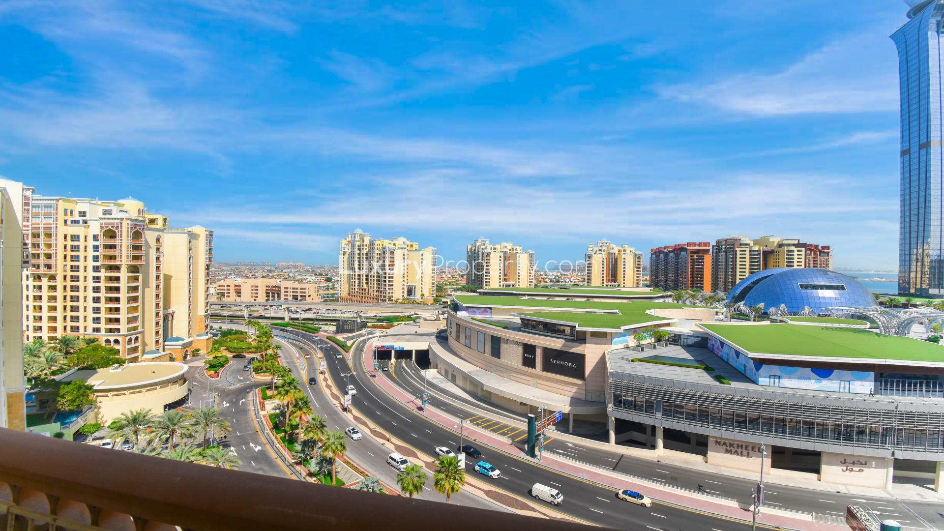 "Stunning marina view from Marina Residence apartment balcony, Palm Jumeirah, available for rent.","View from Marina Residence apartment overlooking Palm Jumeirah skyline and Nakheel Mall.",Vacant bedroom in Marina Residence apartment with balcony view, Palm Jumeirah