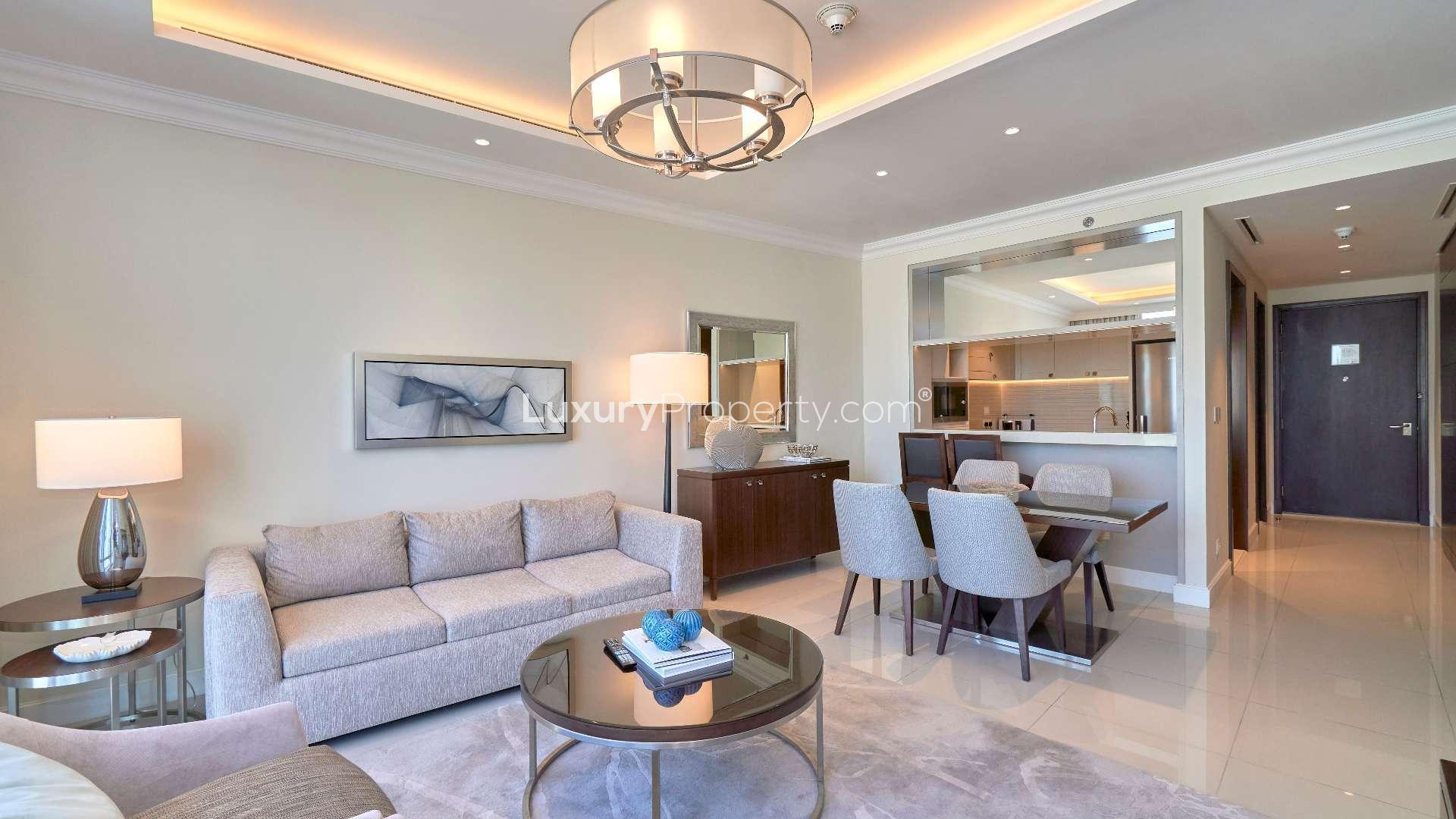 Fully furnished living room in Downtown Dubai apartment, modern decor, open kitchen view