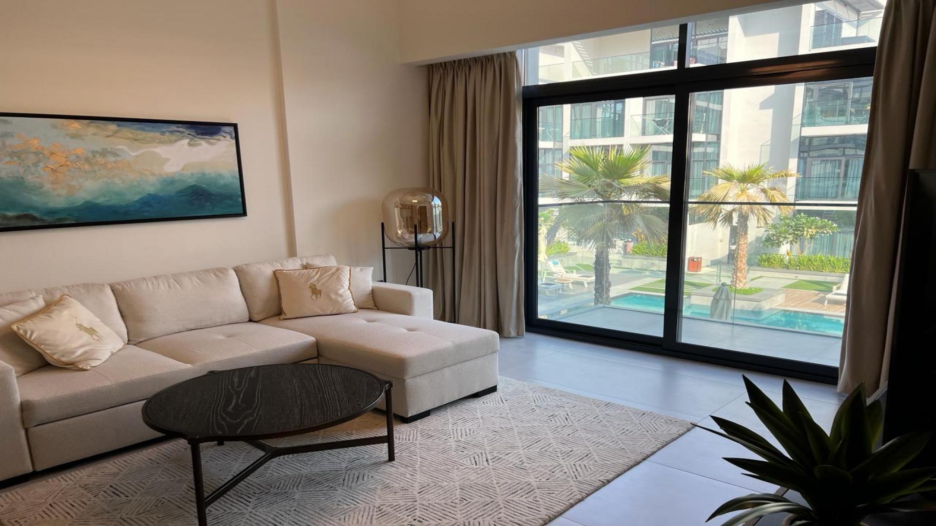 Furnished apartment living room with pool view in Jumeirah Village Circle, Oxford Boulevard