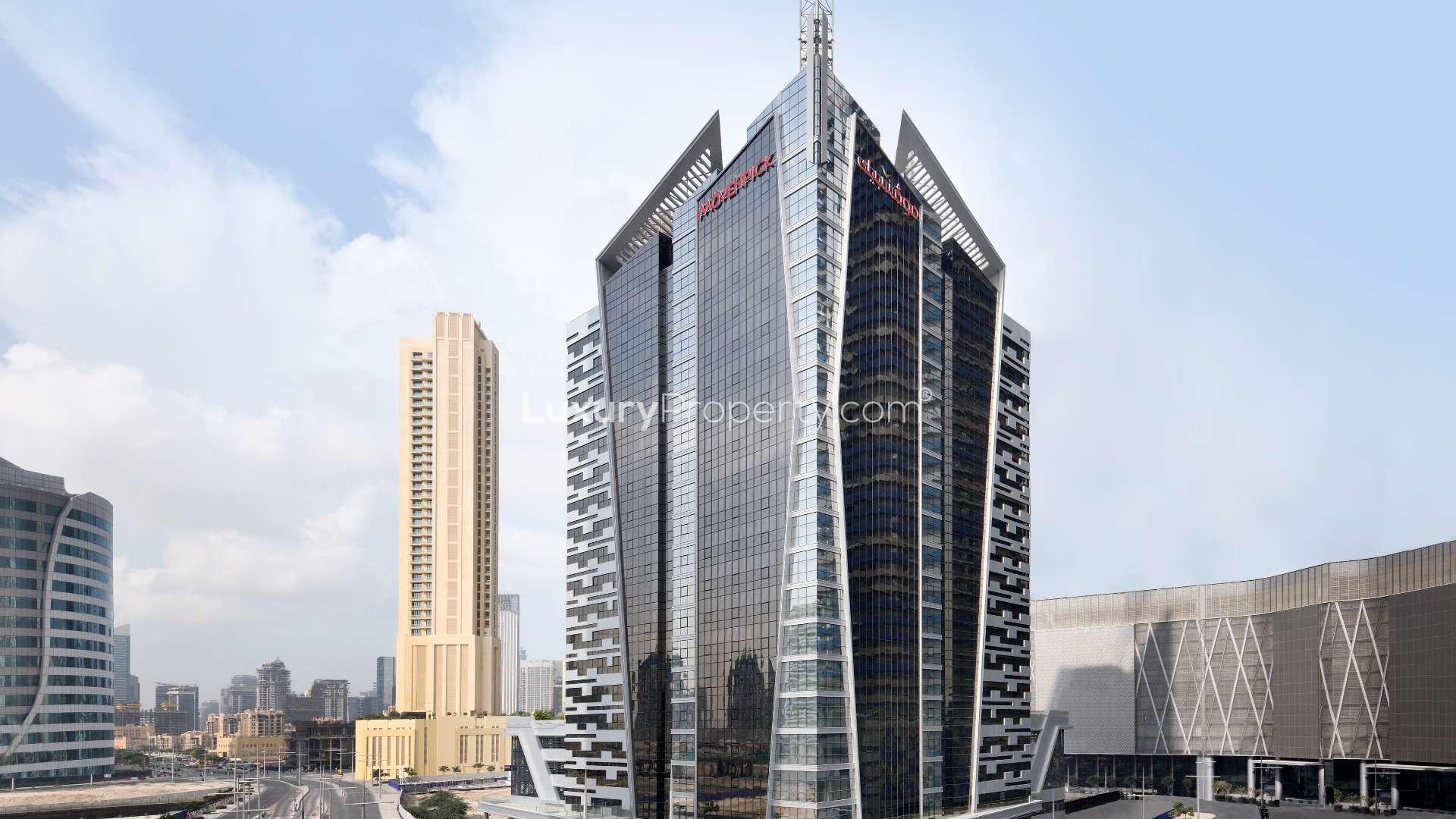 Outdoor pool area at Movenpick Hotel Apartments, Downtown Dubai, with city skyline views