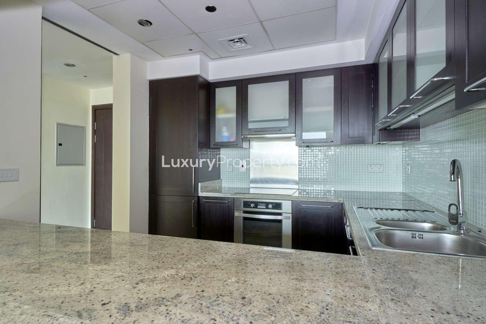 Modern kitchen in 1-bedroom apartment, Mosela, The Views, with granite countertops and dark cabinets