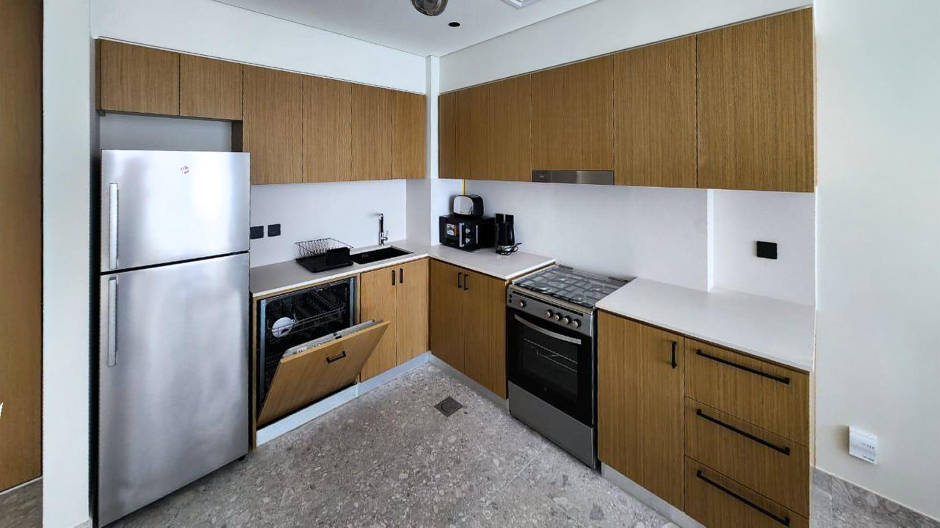 Modern kitchen in fully furnished Dubai Hills Estate apartment, featuring sleek appliances and cabinetry