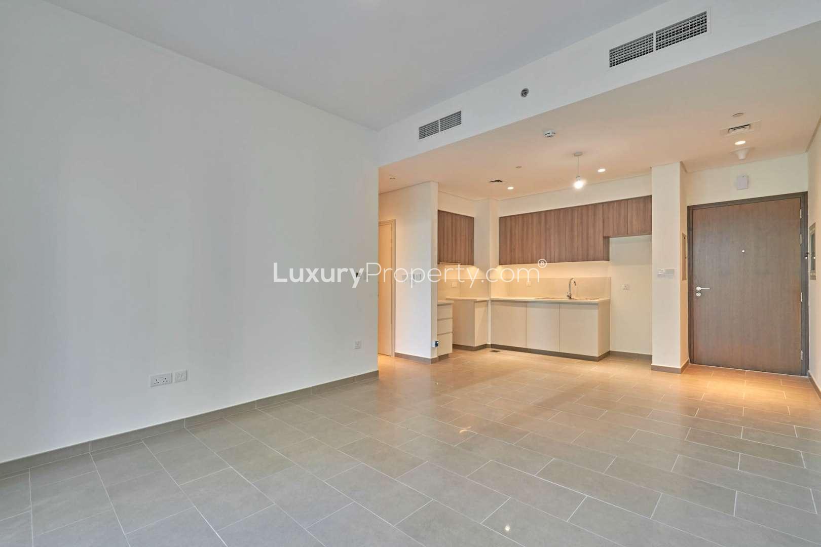 Empty living room with large windows in Dubai Hills Estate apartment for rent