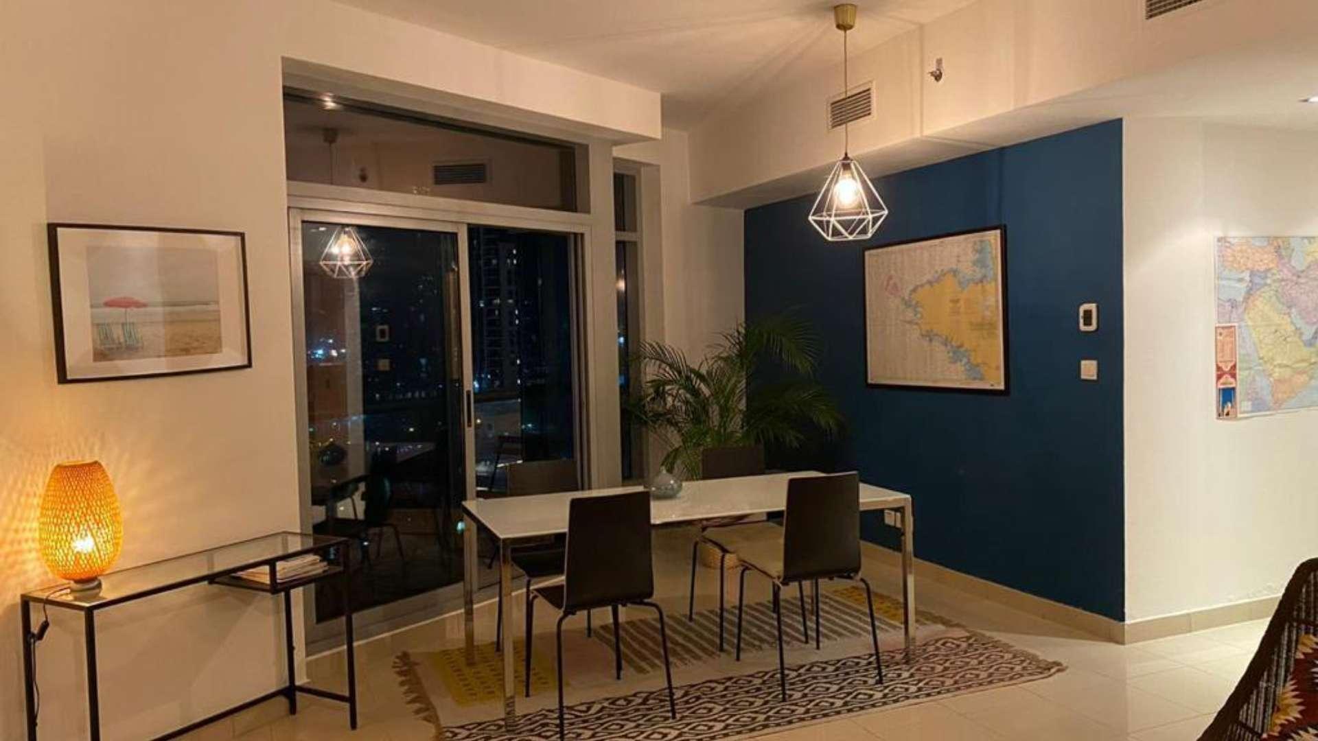 Dining area in spacious Dubai Marina apartment with modern decor and large window view