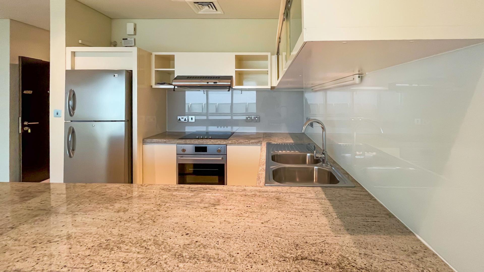 Open-plan kitchen and living area in stylish 1-bedroom apartment, Park Place Tower, Dubai