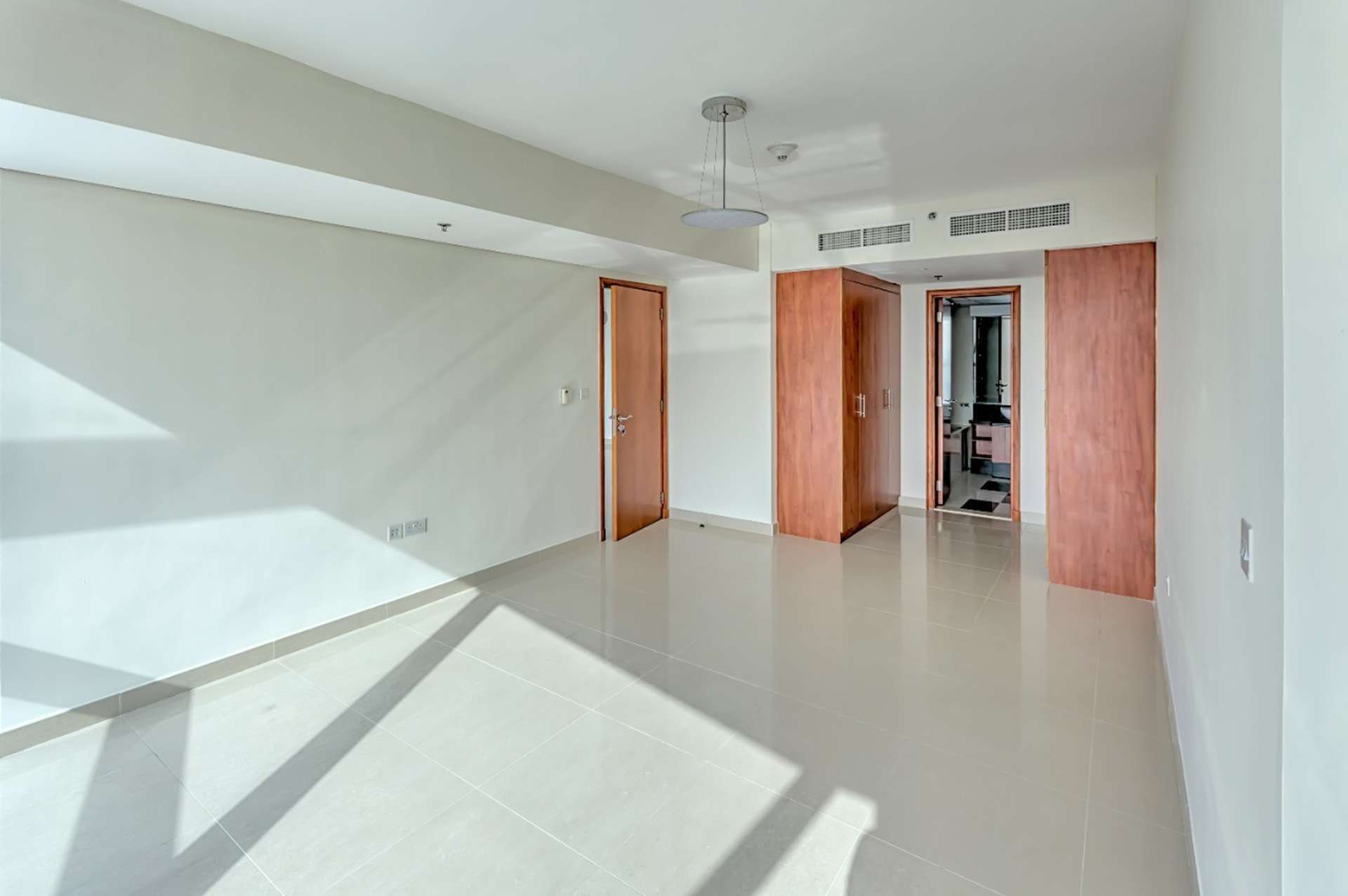 Empty living room in spacious 1-bedroom apartment, Park Towers DIFC, with natural light
