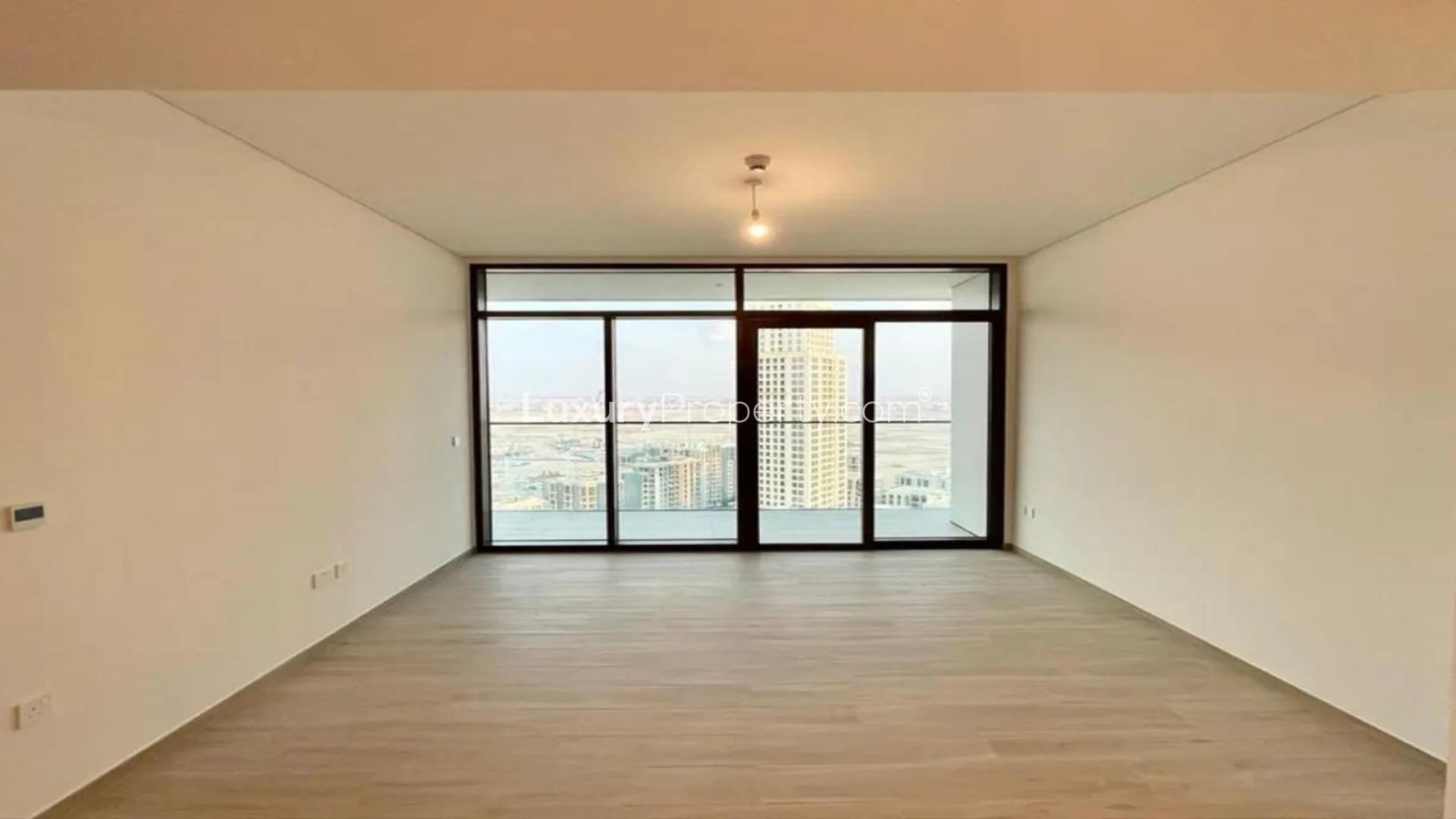"Stunning Dubai Creek Harbour view from Palace Residences apartment balcony, available for rent.",Empty living room with large windows in Dubai Creek Harbour apartment for rent