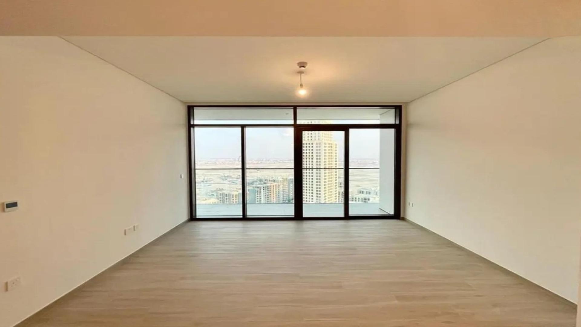 "Stunning Dubai Creek Harbour view from Palace Residences apartment balcony, available for rent.",Empty living room with large windows in Dubai Creek Harbour apartment for rent