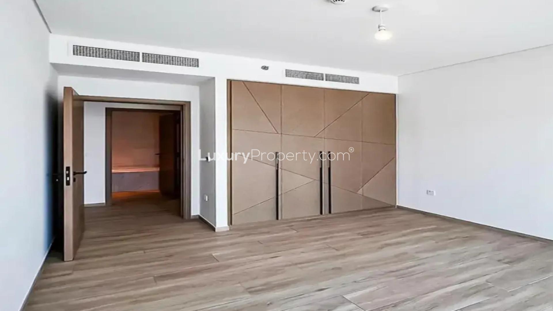 Modern bedroom in Palace Residences apartment, Dubai Creek Harbour, with wooden flooring and built-in wardrobe