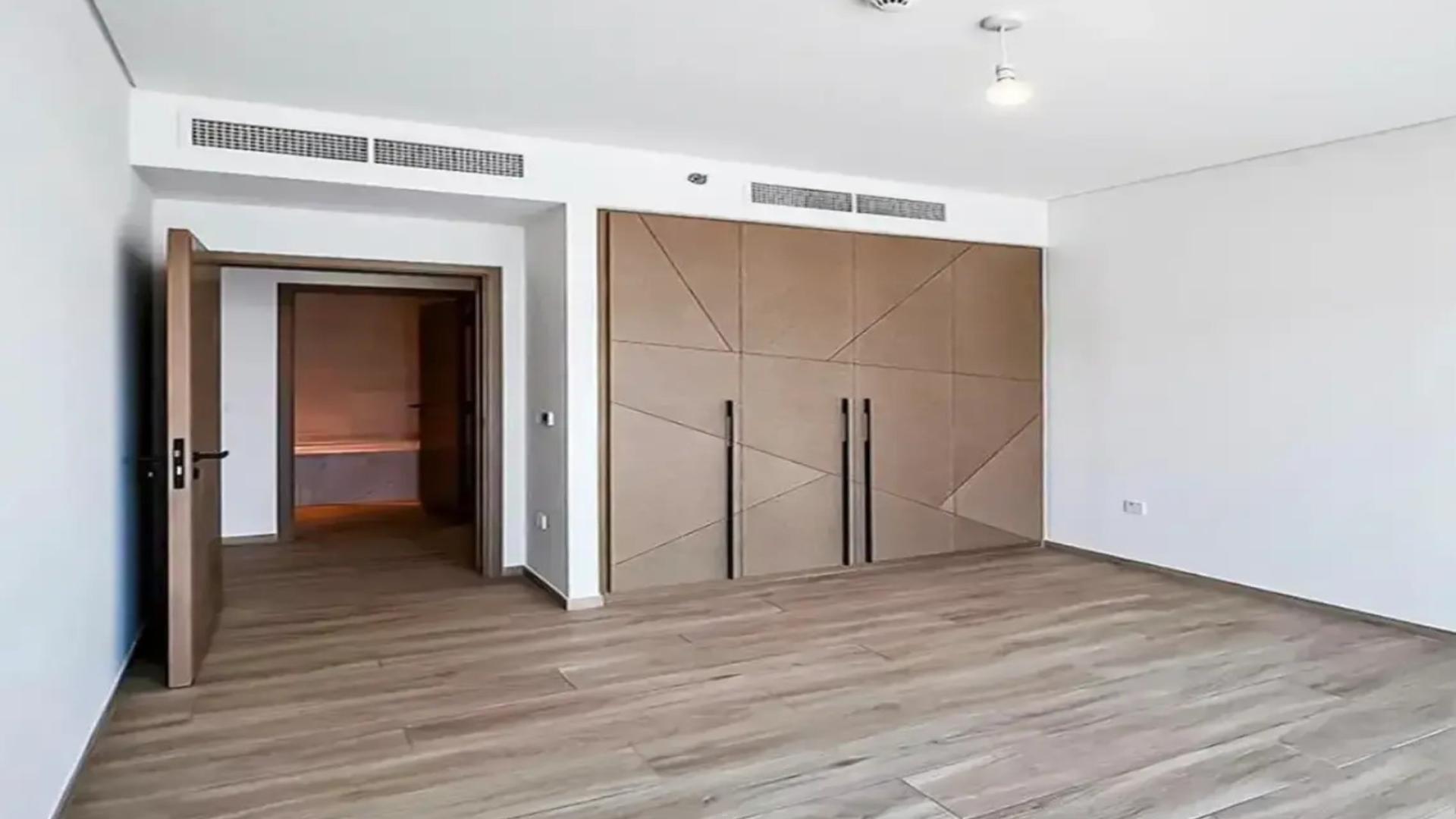 Modern bedroom in Palace Residences apartment, Dubai Creek Harbour, with wooden flooring and built-in wardrobe