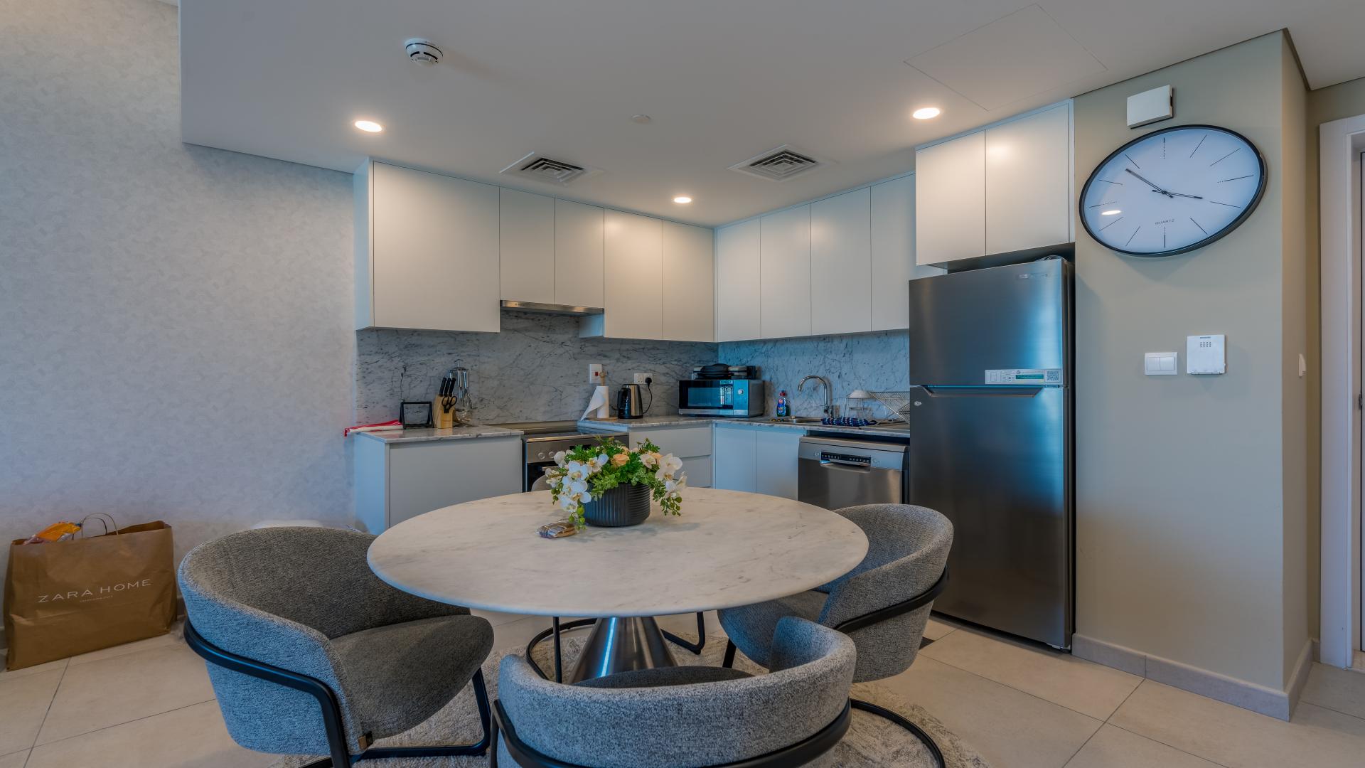 Modern living room and kitchen in Dubai apartment, open layout with stylish furniture