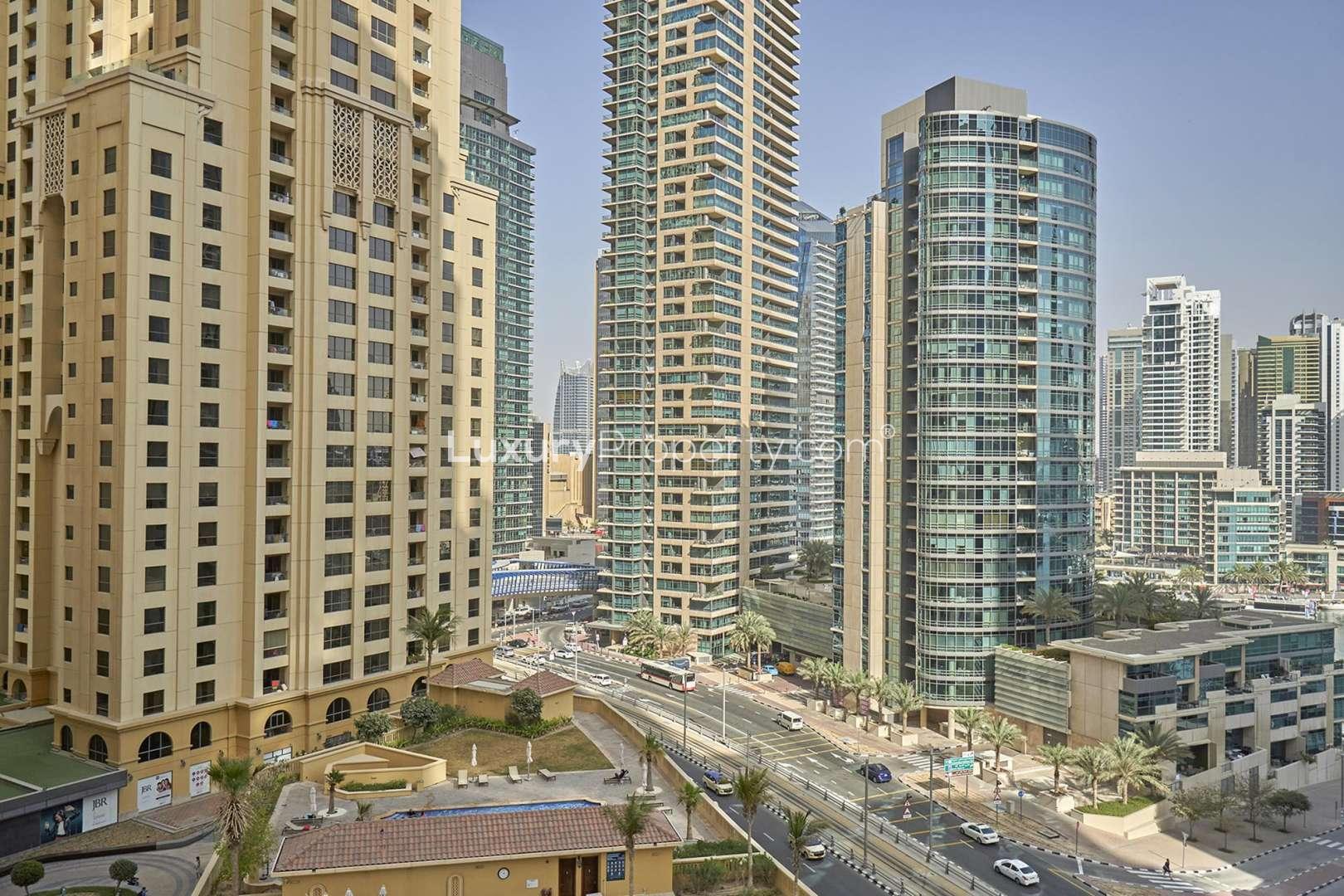 "Spacious living room in Rimal 4 one-bedroom apartment, Jumeirah Beach Residence for rent.",Jumeirah Beach Residence skyline view from Rimal 4 apartment, spacious one-bedroom for rent