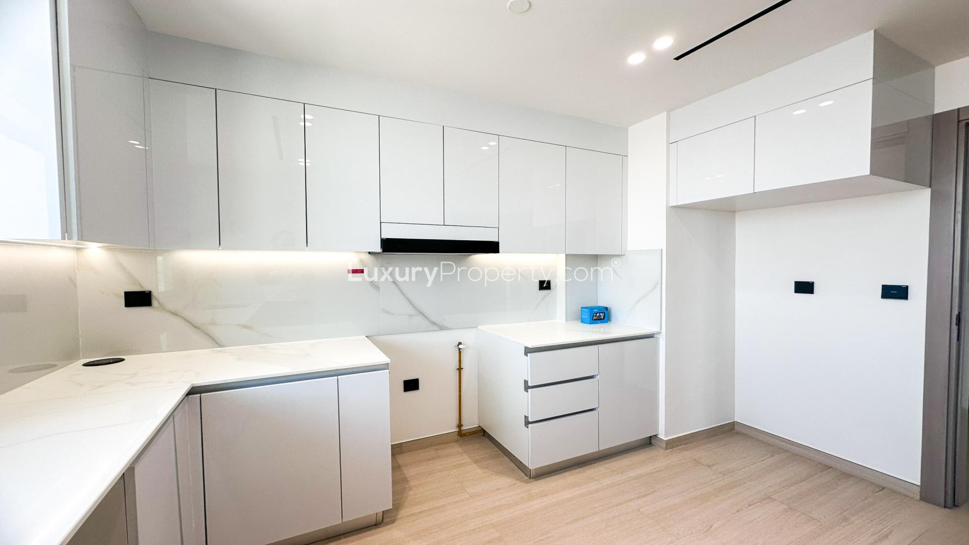 Modern closed kitchen in high-floor Jumeirah Village Circle apartment, District 12, for rent
