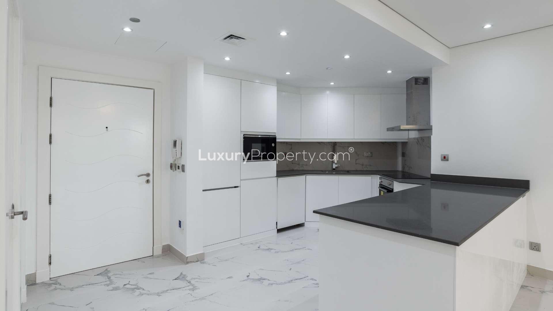 Spacious living room in one-bedroom Shoreline apartment, Palm Jumeirah, with modern chandelier and balcony