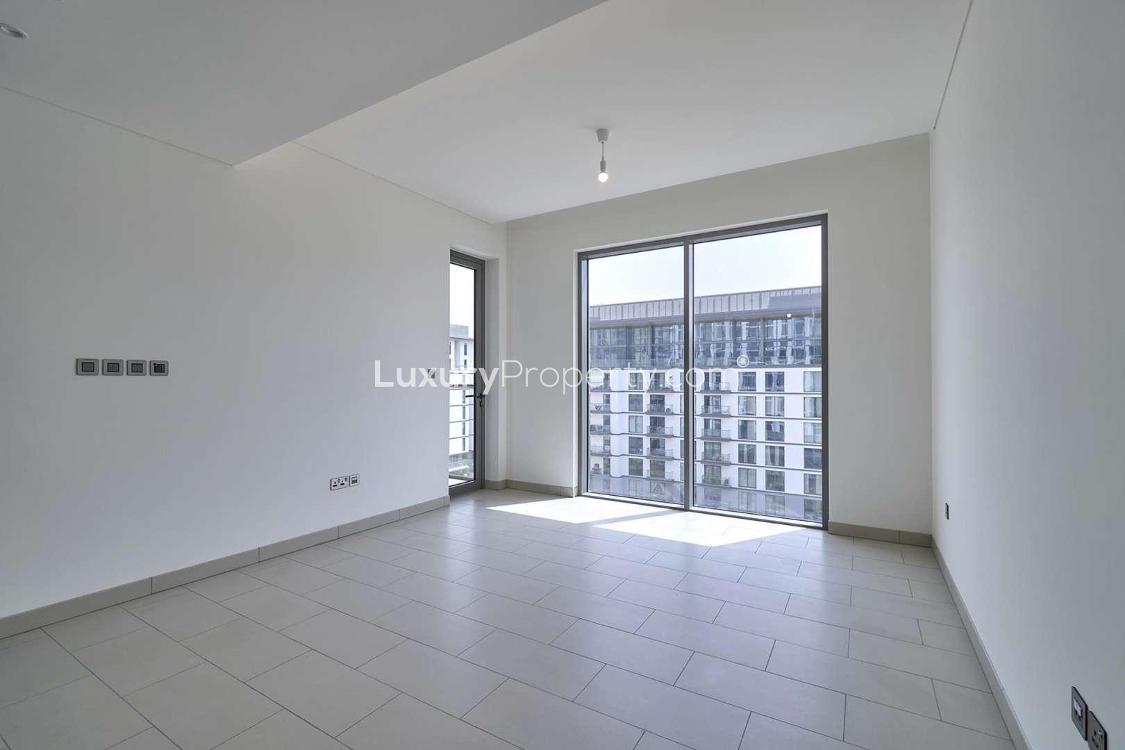 Brightly lit apartment interior with washer and bathroom in Sobha Hartland, Mohammed Bin Rashid City