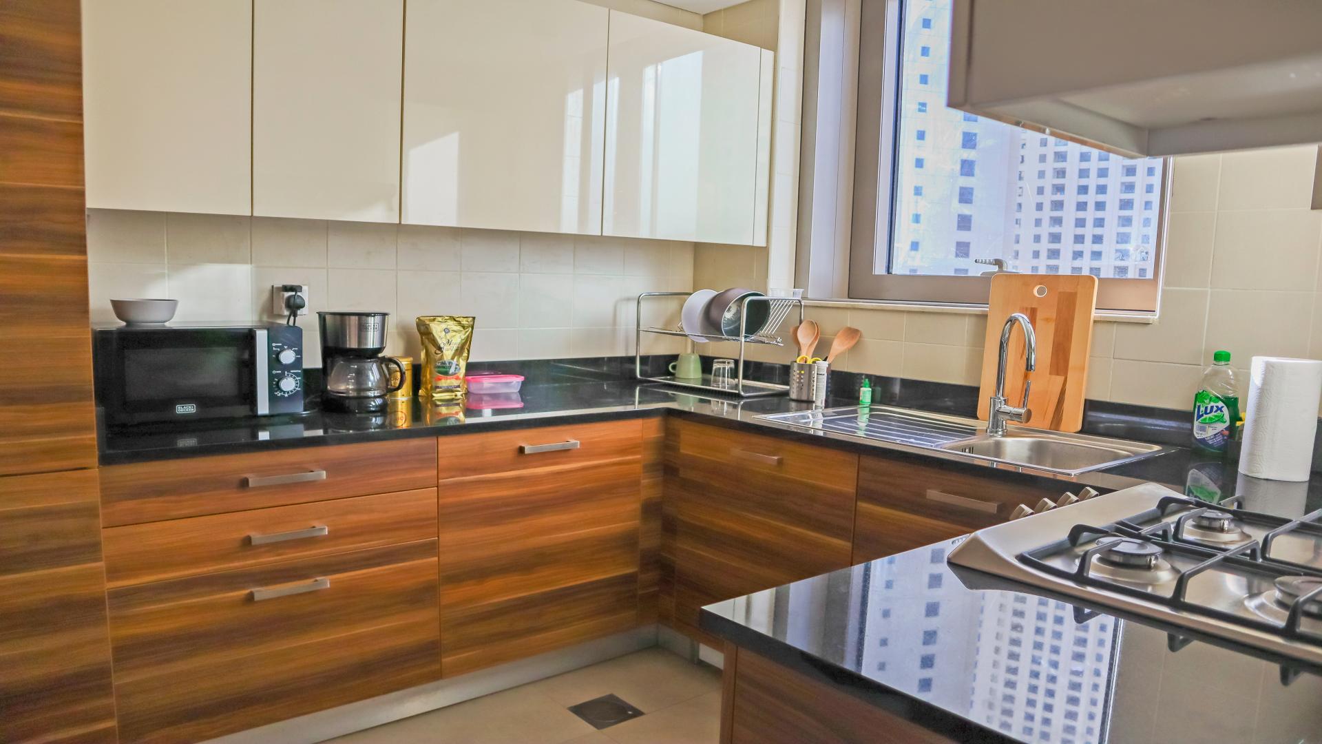 Outdoor pool area at Sparkle Towers, Dubai Marina, with modern design and palm trees