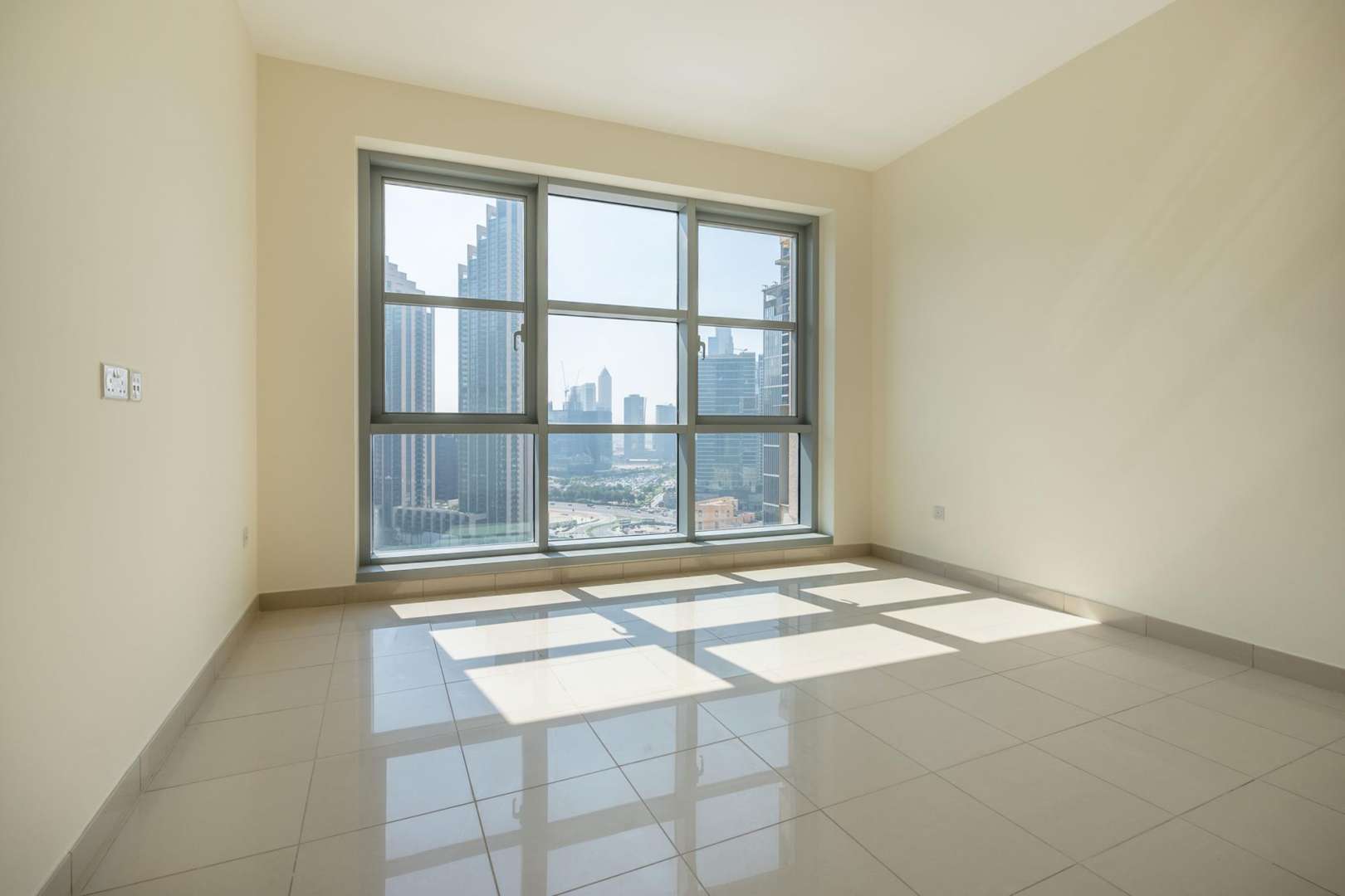 Empty bedroom in Standpoint Tower apartment, Downtown Dubai, with open door and sunlight