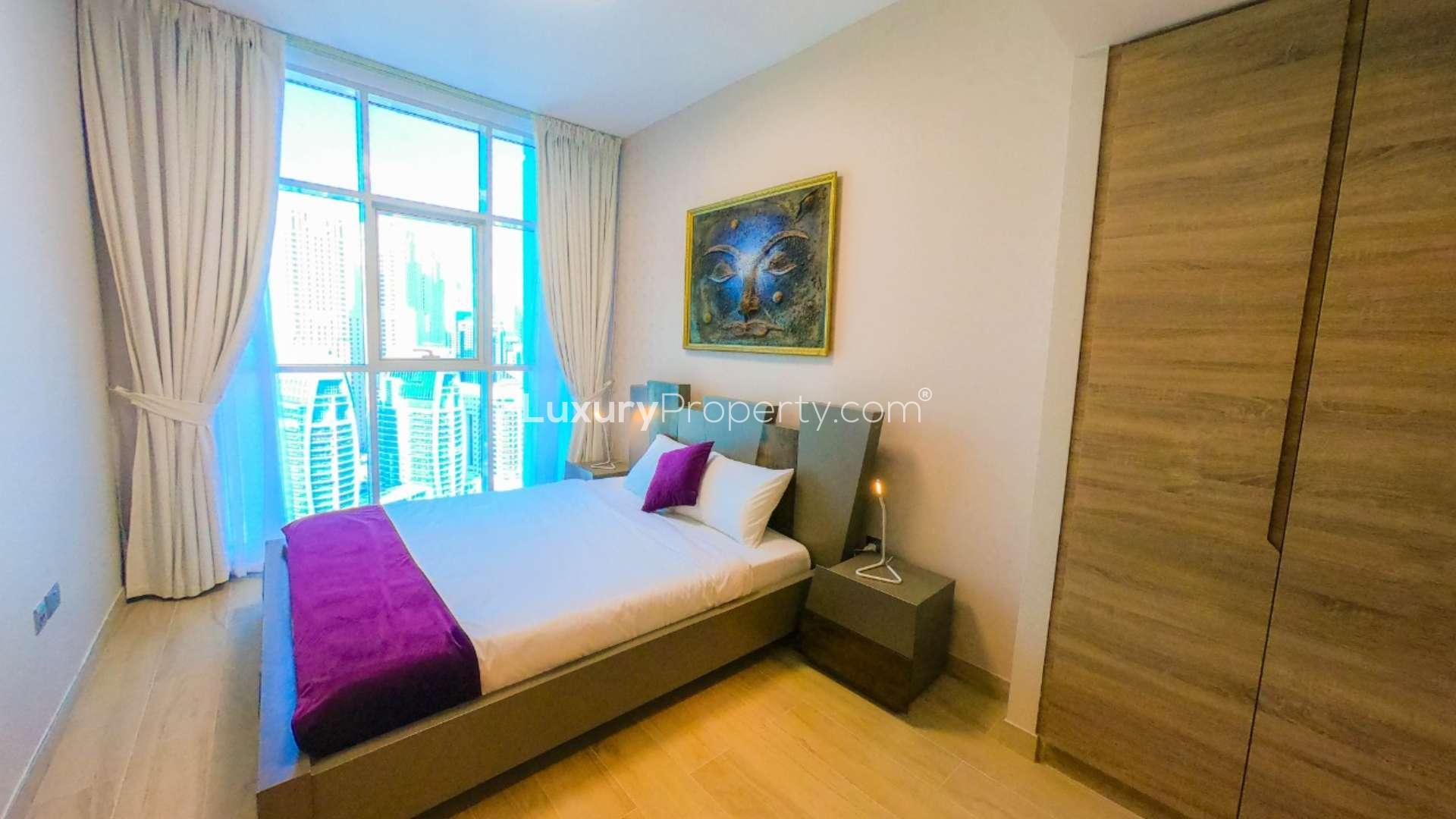 Modern furnished bedroom in Dubai Marina apartment, featuring en-suite bathroom and stylish decor