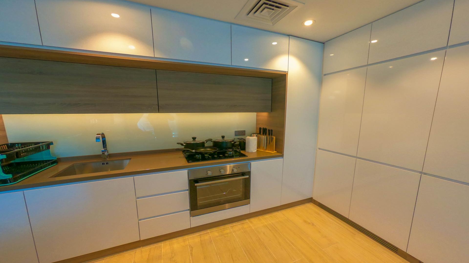 Luxurious Dubai Marina apartment living room with modern kitchen, stylish decor, and vibrant artwork