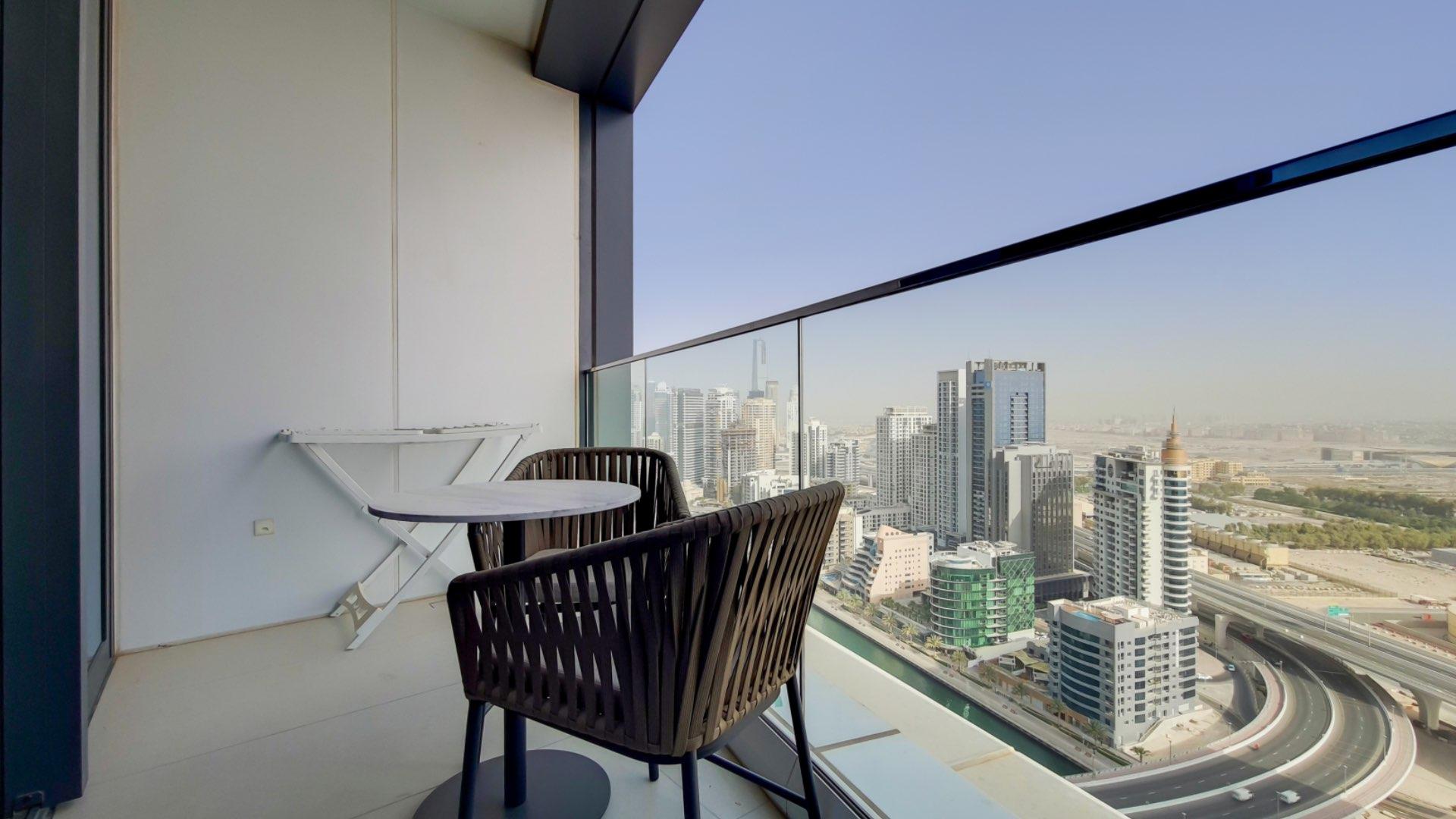 Modern living room in Jumeirah Beach Residence apartment, featuring balcony with city views