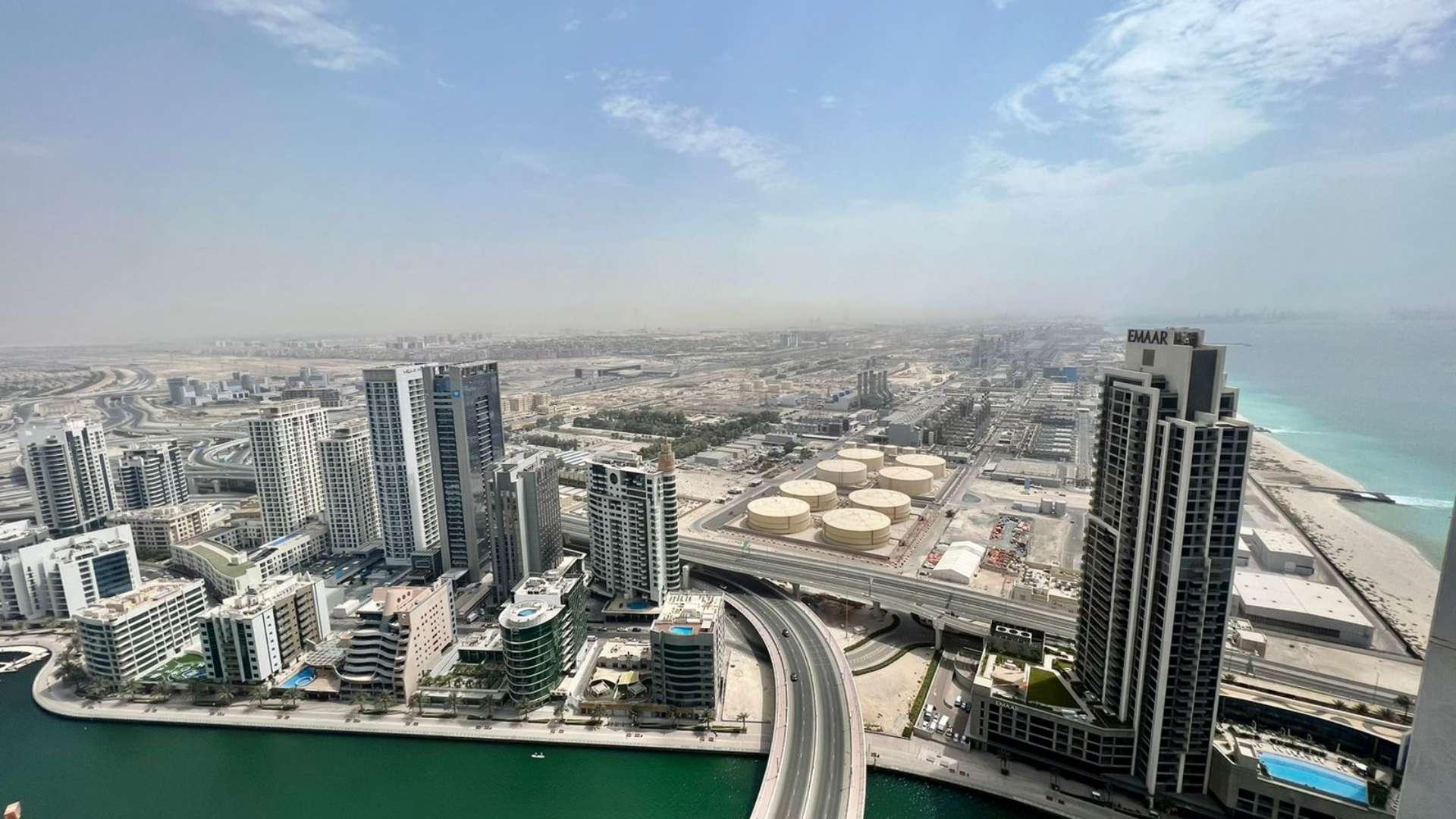 Luxury JBR apartment living room with modern decor, sofa, and kitchen view