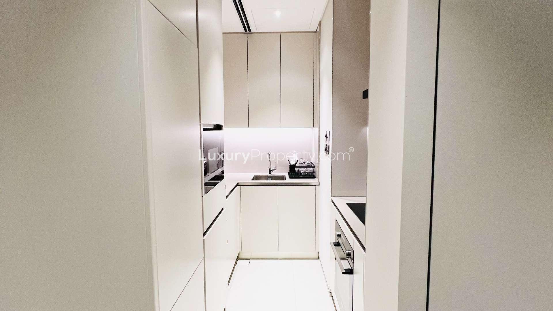 Furnished living area in JBR apartment, modern decor, dining table, TV, stylish shelving