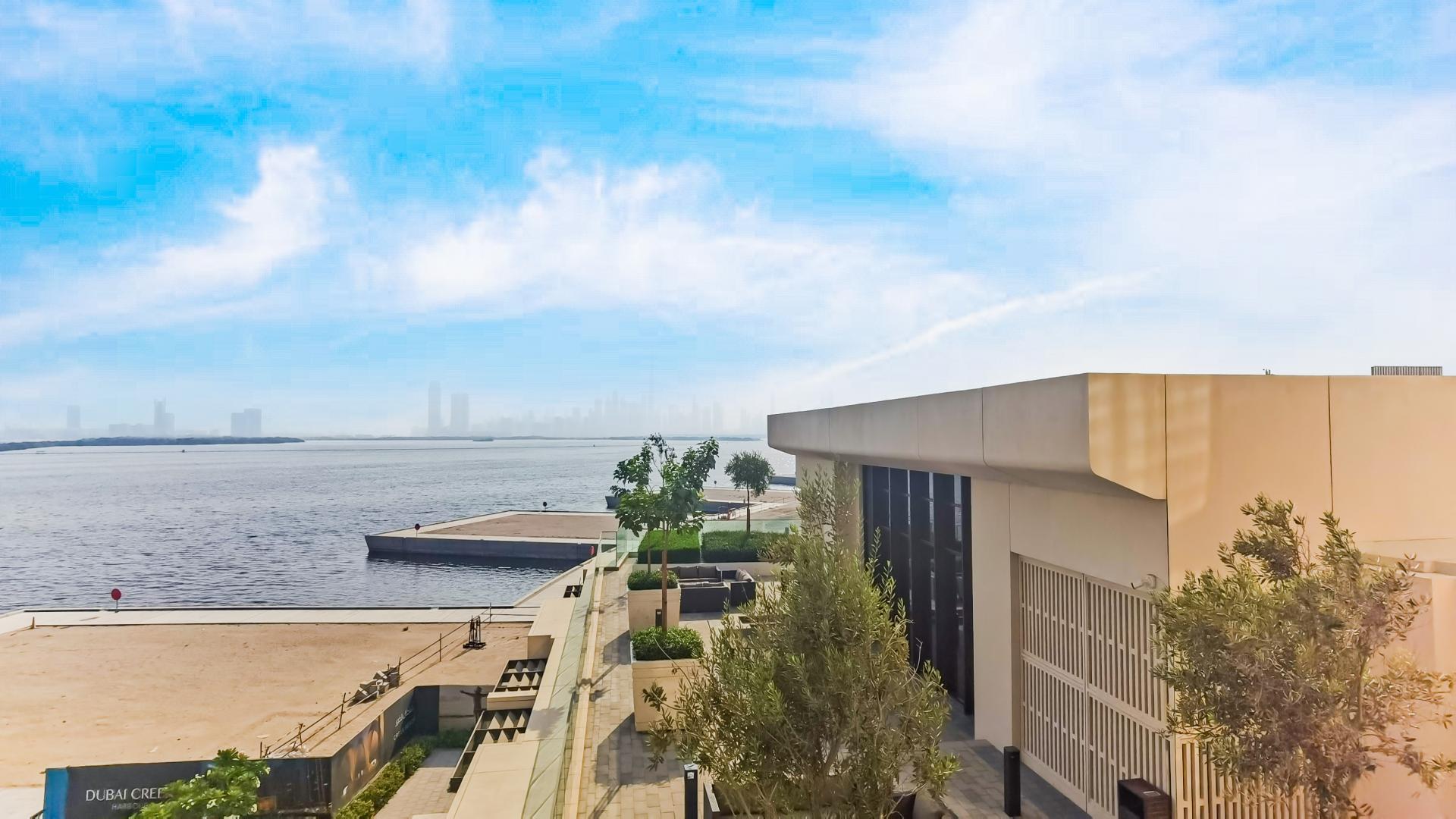 "Balcony view from 1-bedroom apartment in The Cove, Palm Jebel Ali, overlooking water and city.",Brand-new 1-bedroom apartment with stunning waterfront view in Palm Jebel Ali, The Cove