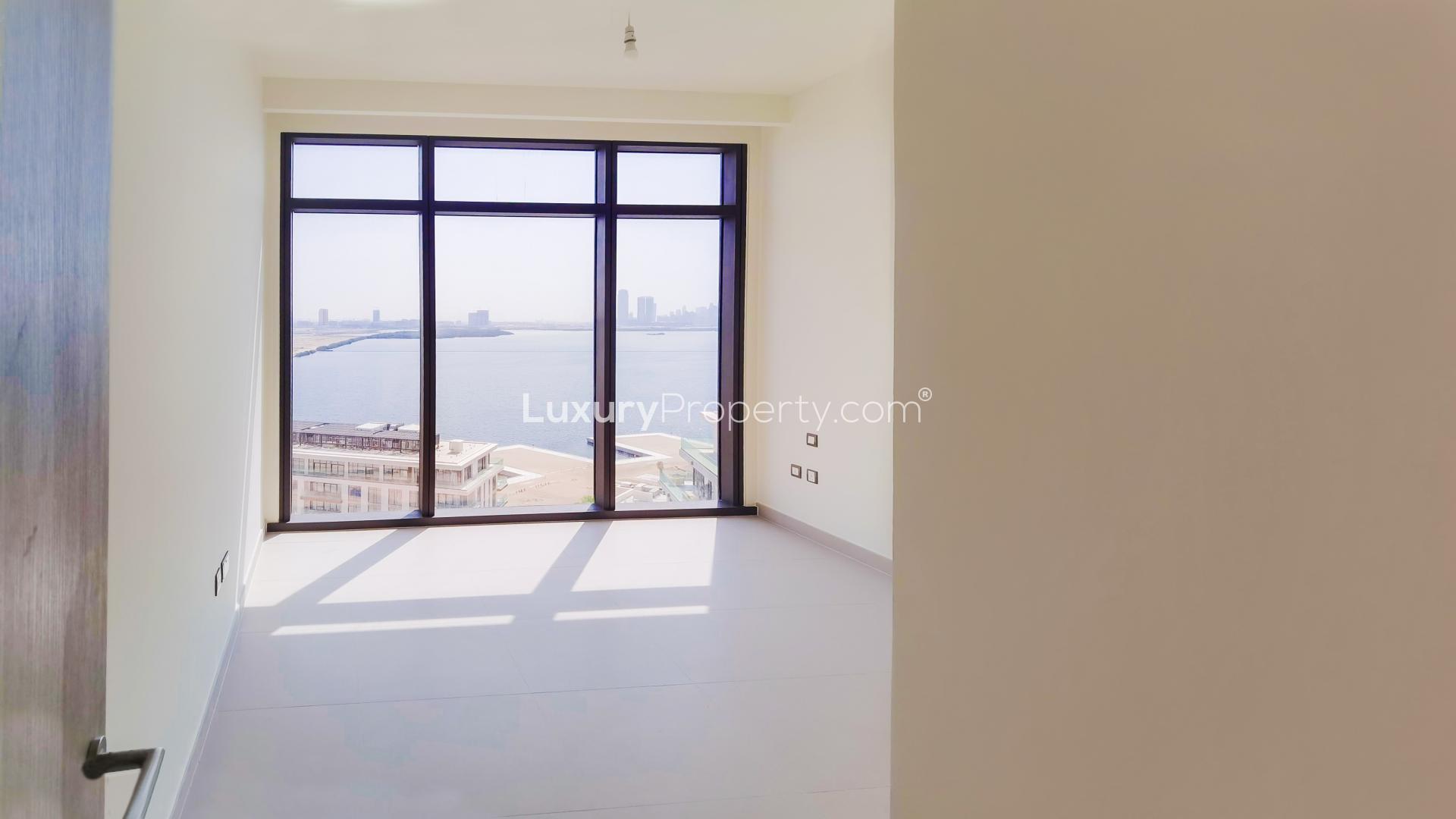Modern living room with large windows in Dubai Creek Harbour apartment, The Cove