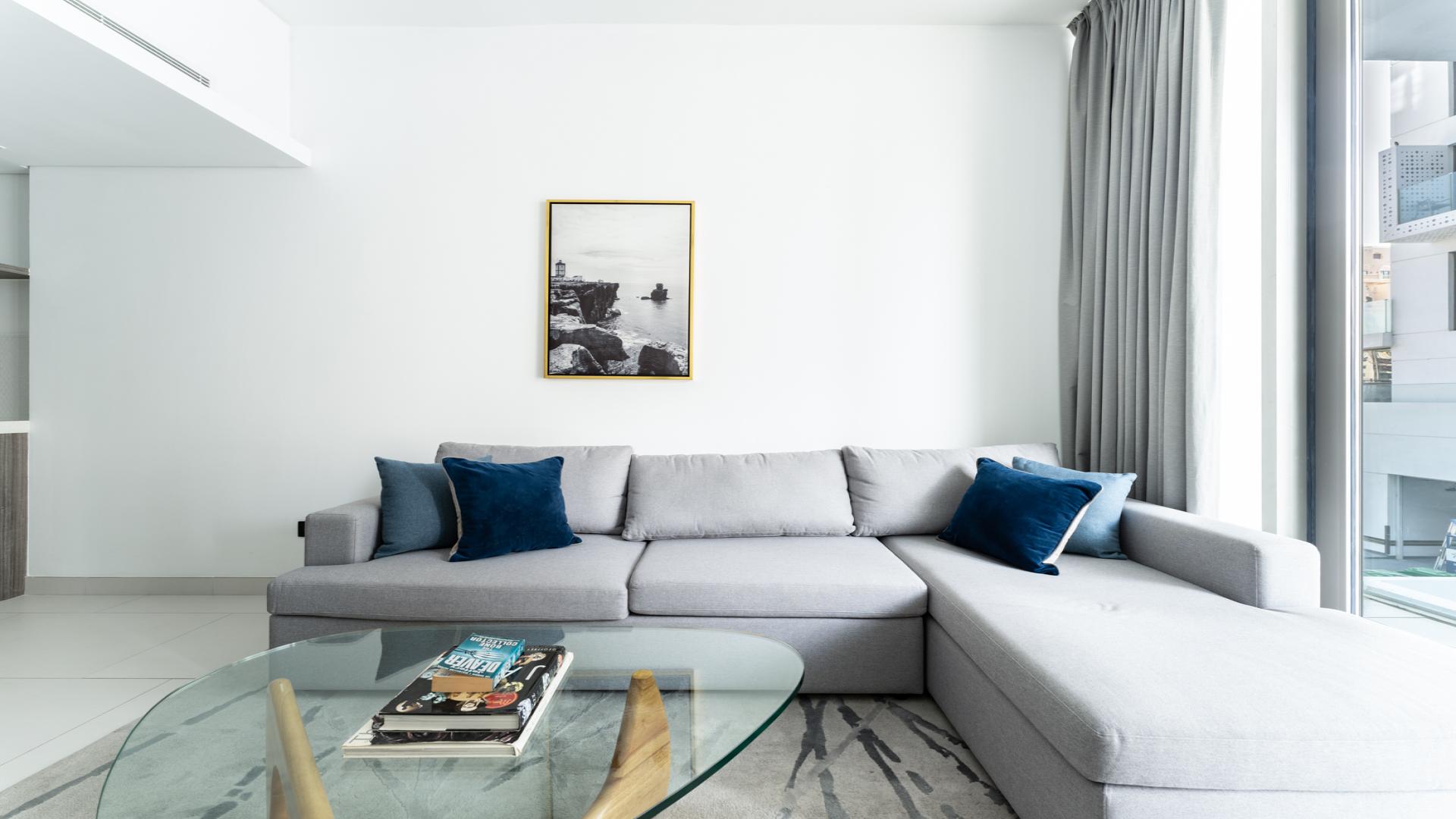 Elegant living room in upgraded 1-bedroom apartment, Soho Palm Jumeirah, with modern decor and sofa