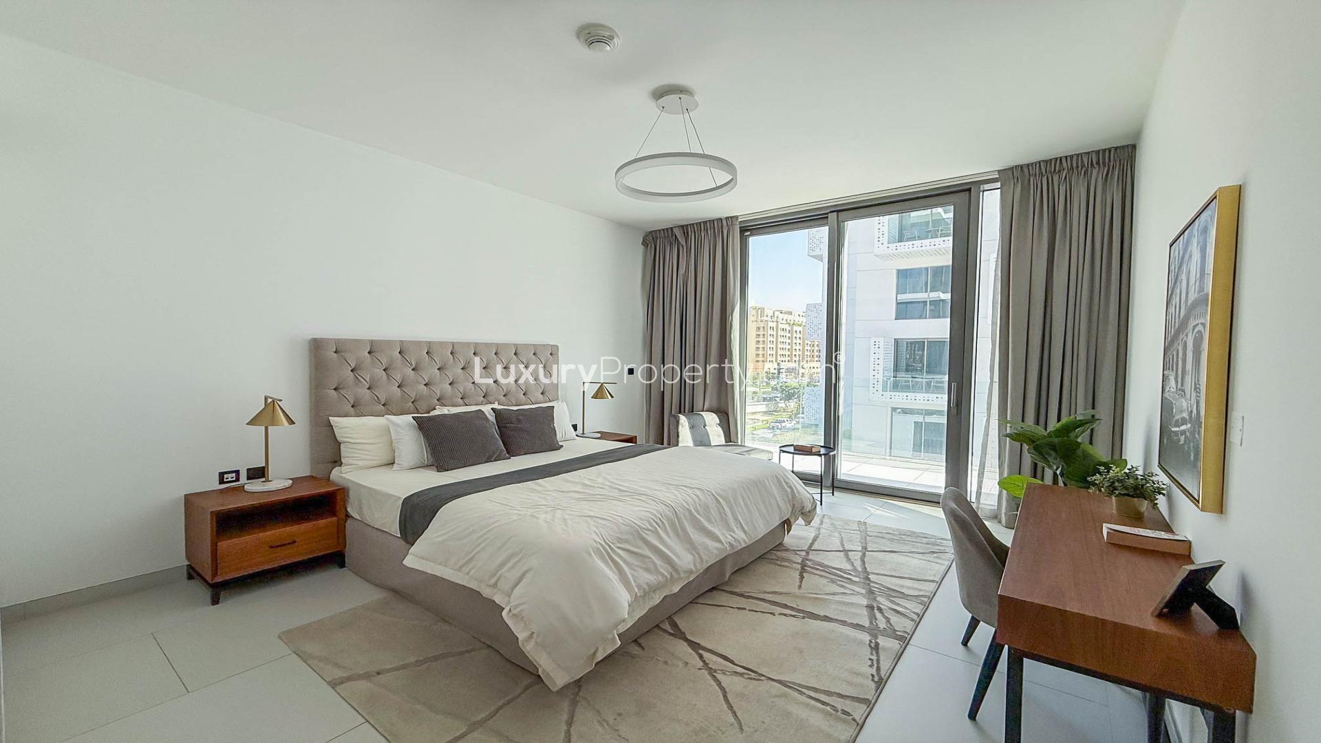 Modern living room in Soho Palm Jumeirah apartment, featuring stylish furniture and open kitchen