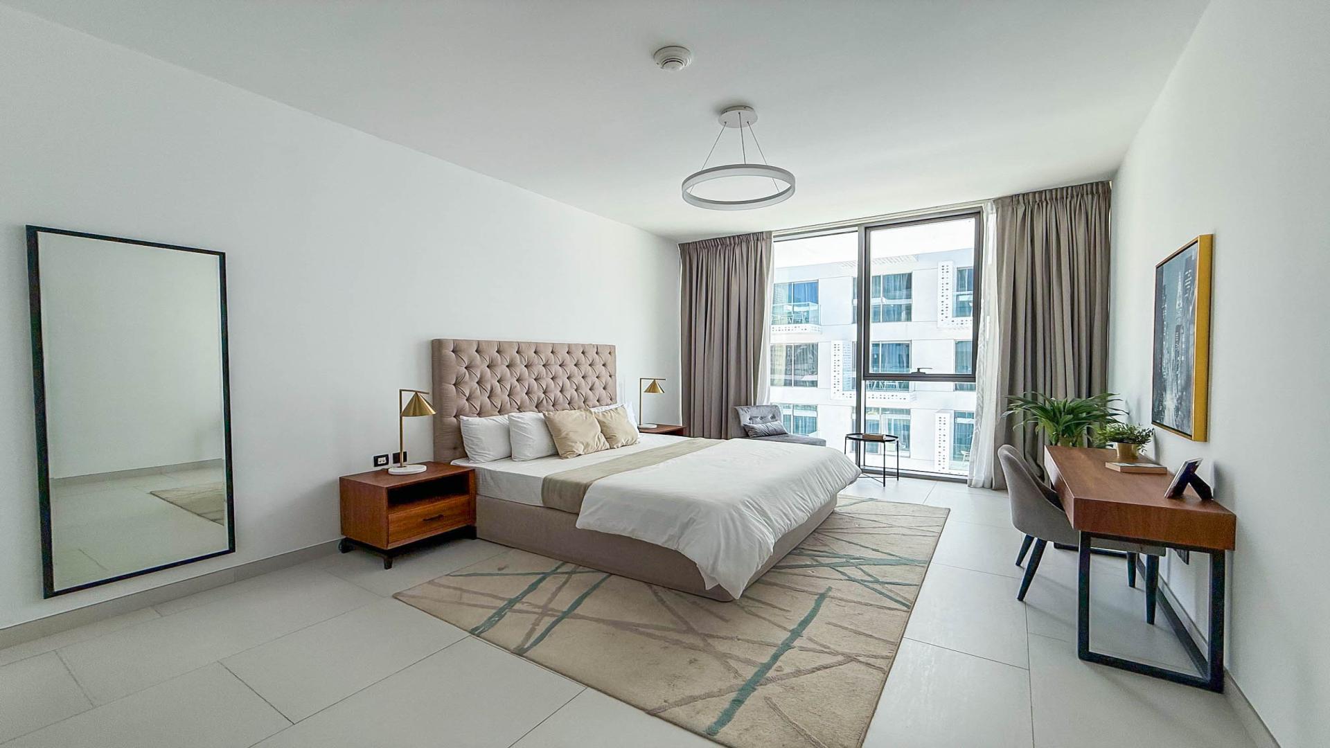 Modern living room in Soho Palm Jumeirah apartment with stylish decor and open kitchen