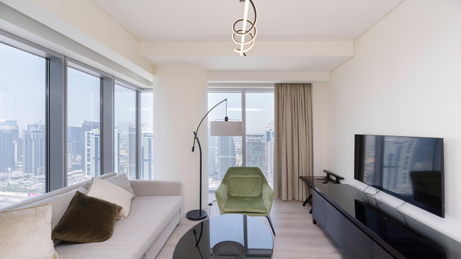 Furnished living room with large windows in The Address Dubai Marina apartment for rent