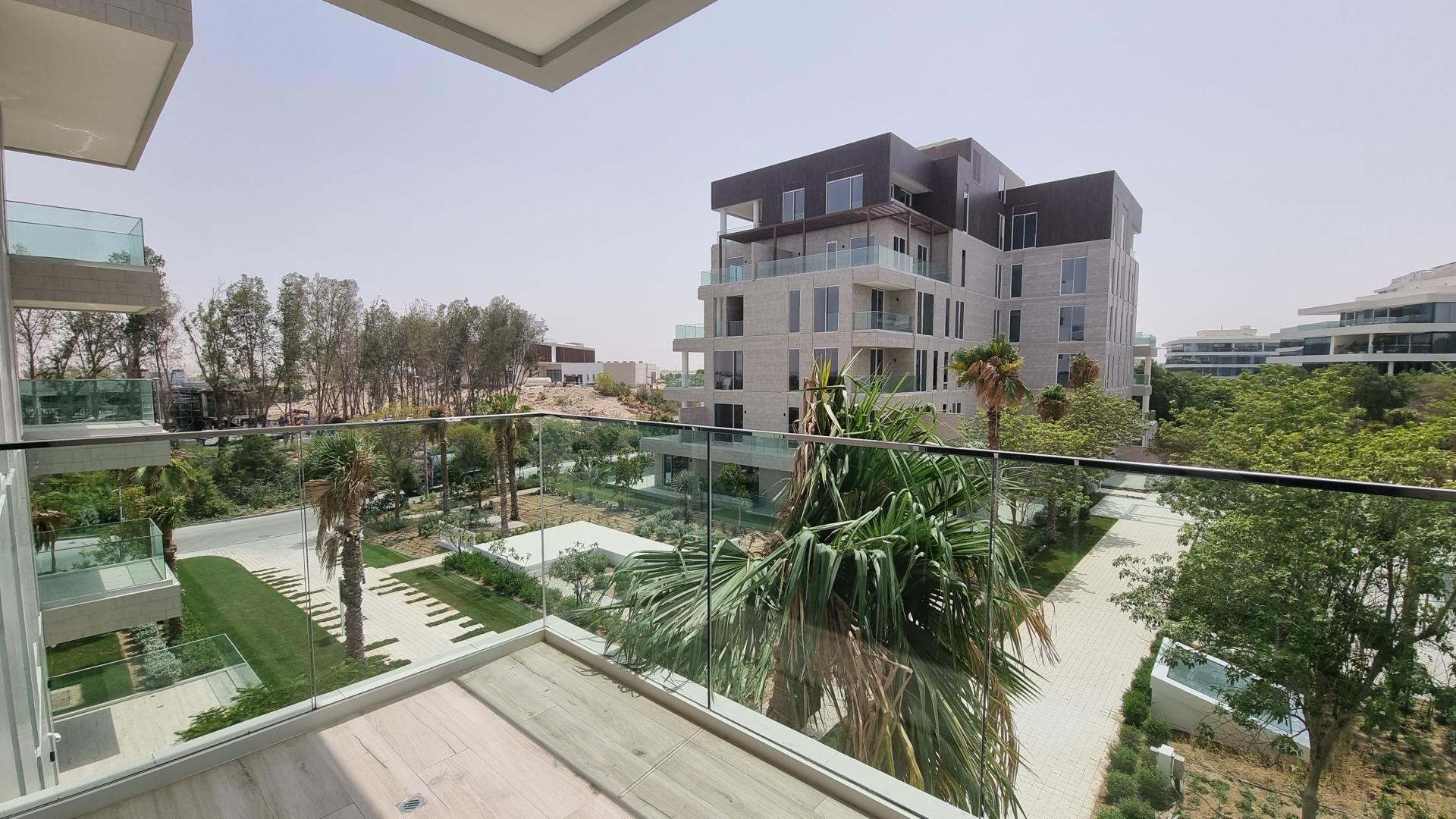 Modern Al Barari apartment interior with kitchen and community views through large windows