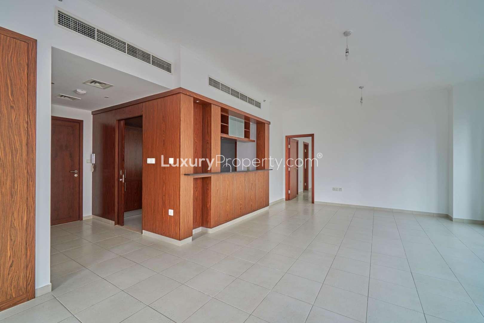 Empty living area in Downtown Dubai apartment with modern wood accents and tiled flooring
