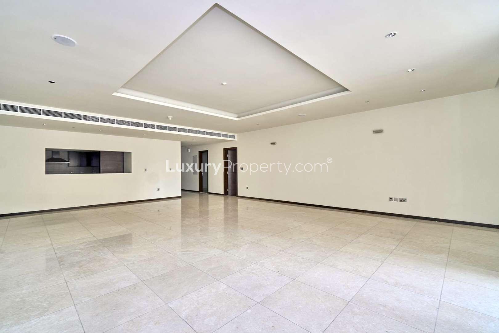 Spacious living room in Tiara Residence apartment, Palm Jumeirah, with large windows and tiled floor