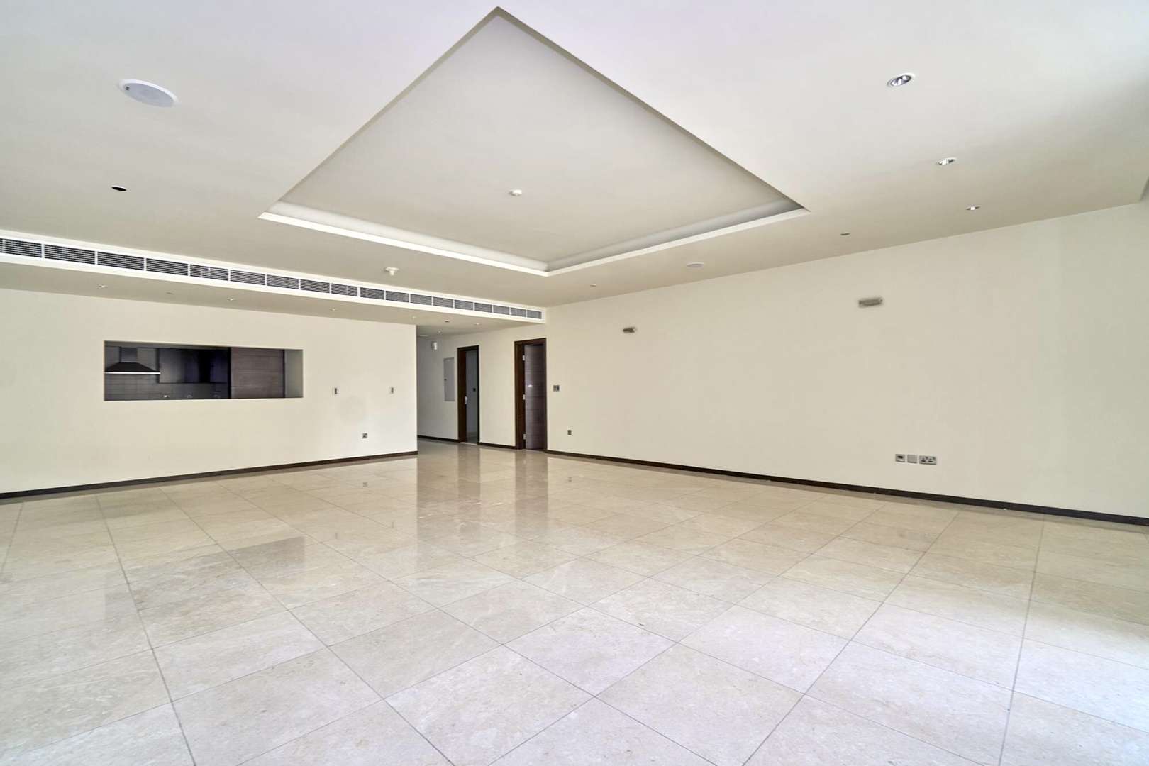 Spacious living room in Tiara Residence apartment, Palm Jumeirah, with large windows and tiled floor