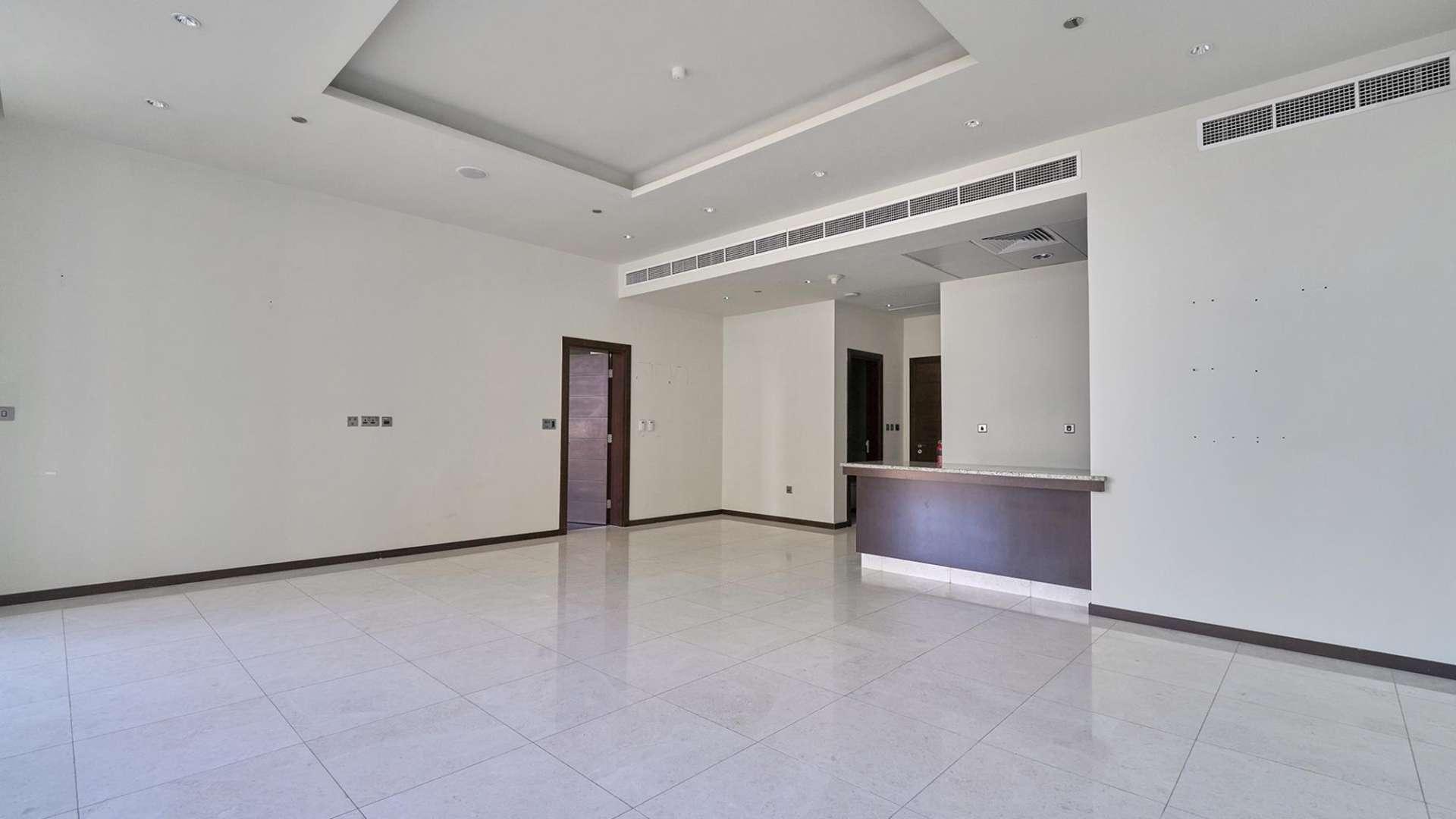 Empty living area with modern kitchen in Tiara Residence apartment, Palm Jumeirah