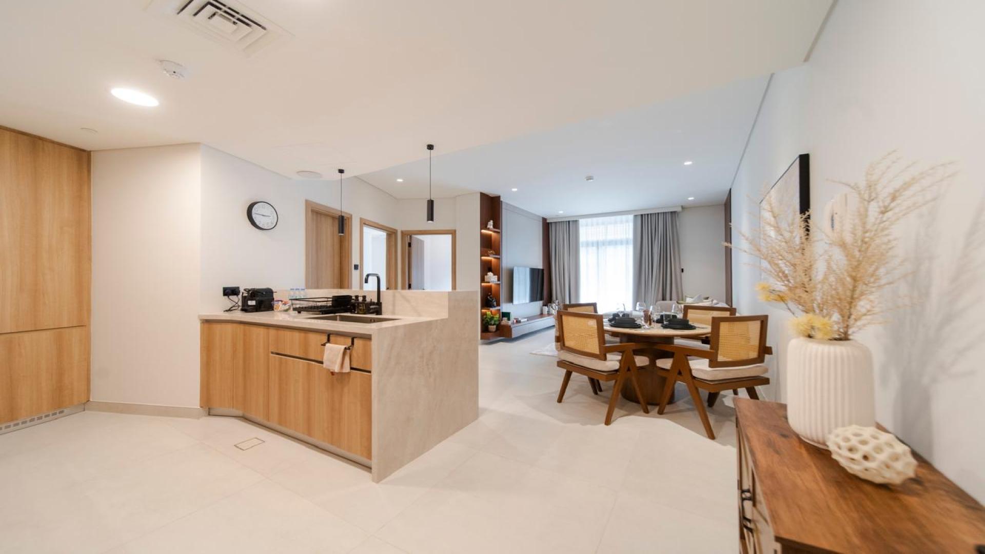 Modern living room in Jumeirah Village Triangle apartment, featuring cozy seating and natural light
