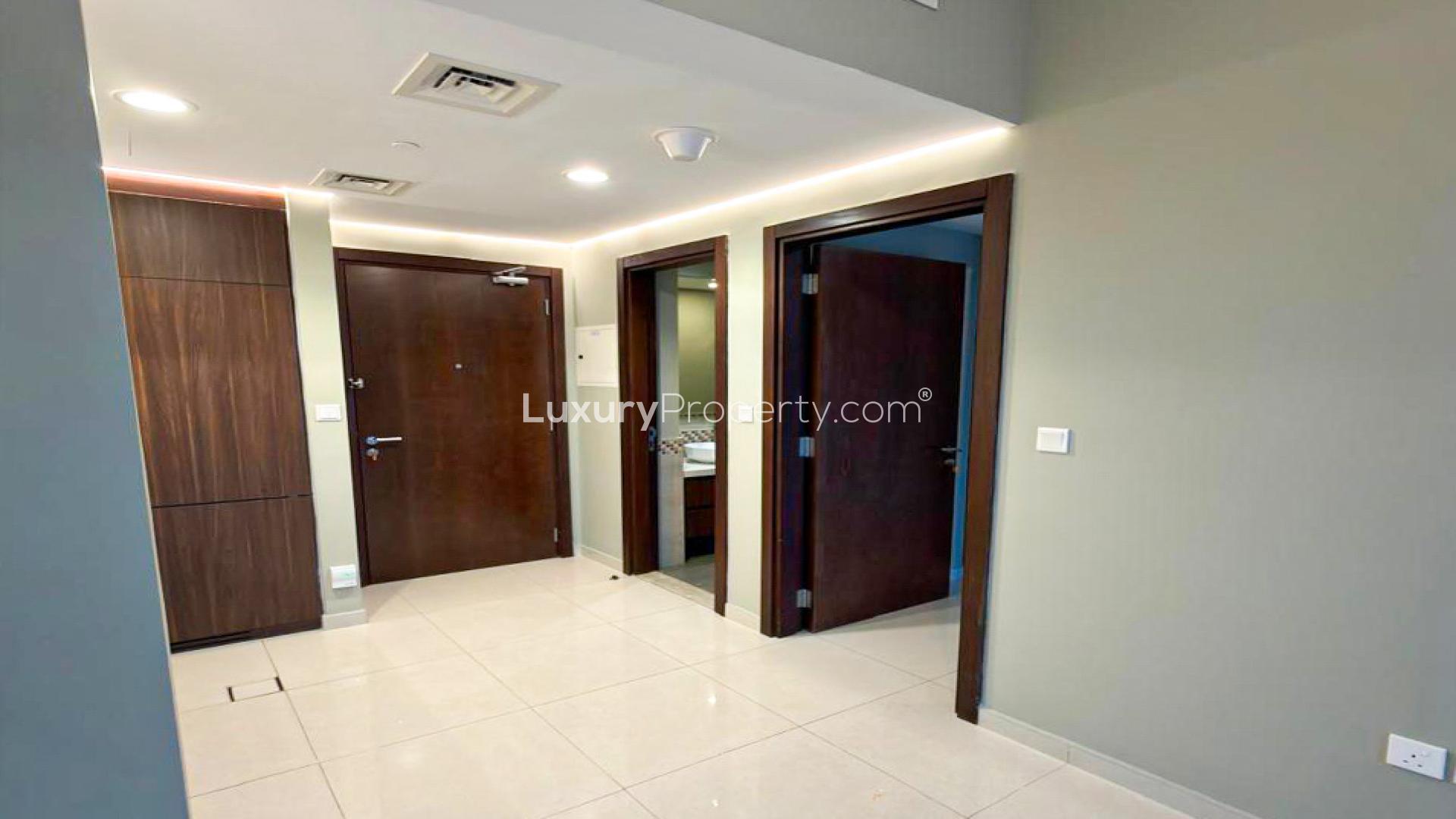 Empty bedroom with tiled floor and built-in wardrobes at Vera Residences, Business Bay