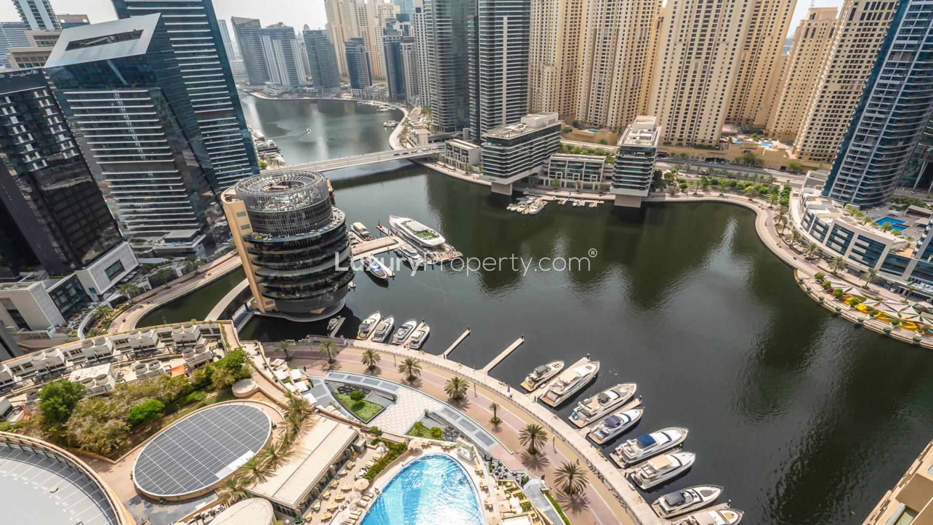 Modern living room in Dubai Marina apartment with sleek furnishings and open kitchen layout