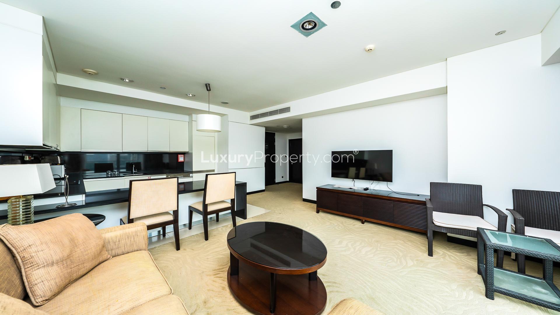 Modern living room in Dubai Marina apartment with sleek furnishings and open kitchen layout