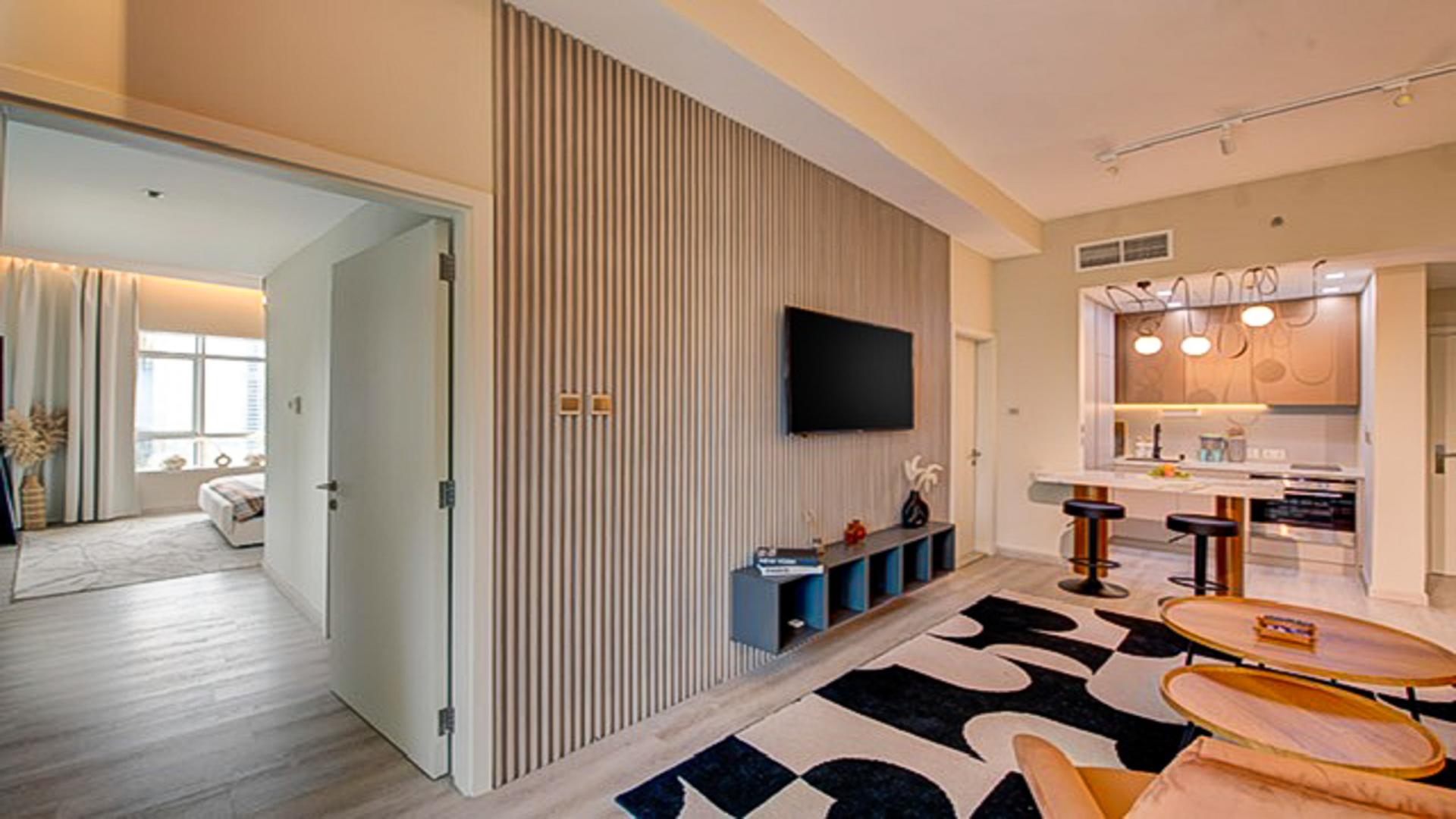 Renovated living room in JLT Cluster D apartment with modern decor and open kitchen layout