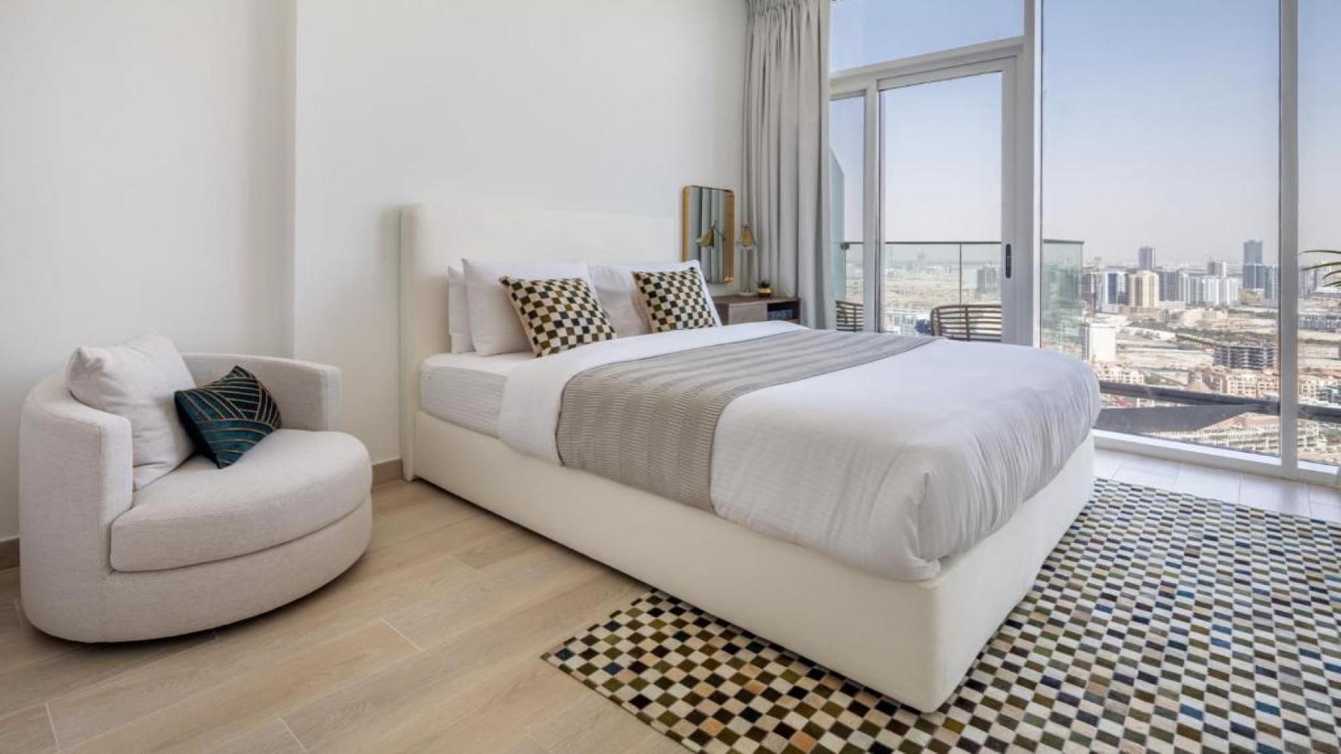 Bloom Towers apartment exterior in Jumeirah Village Circle, Dubai. Modern architecture and greenery