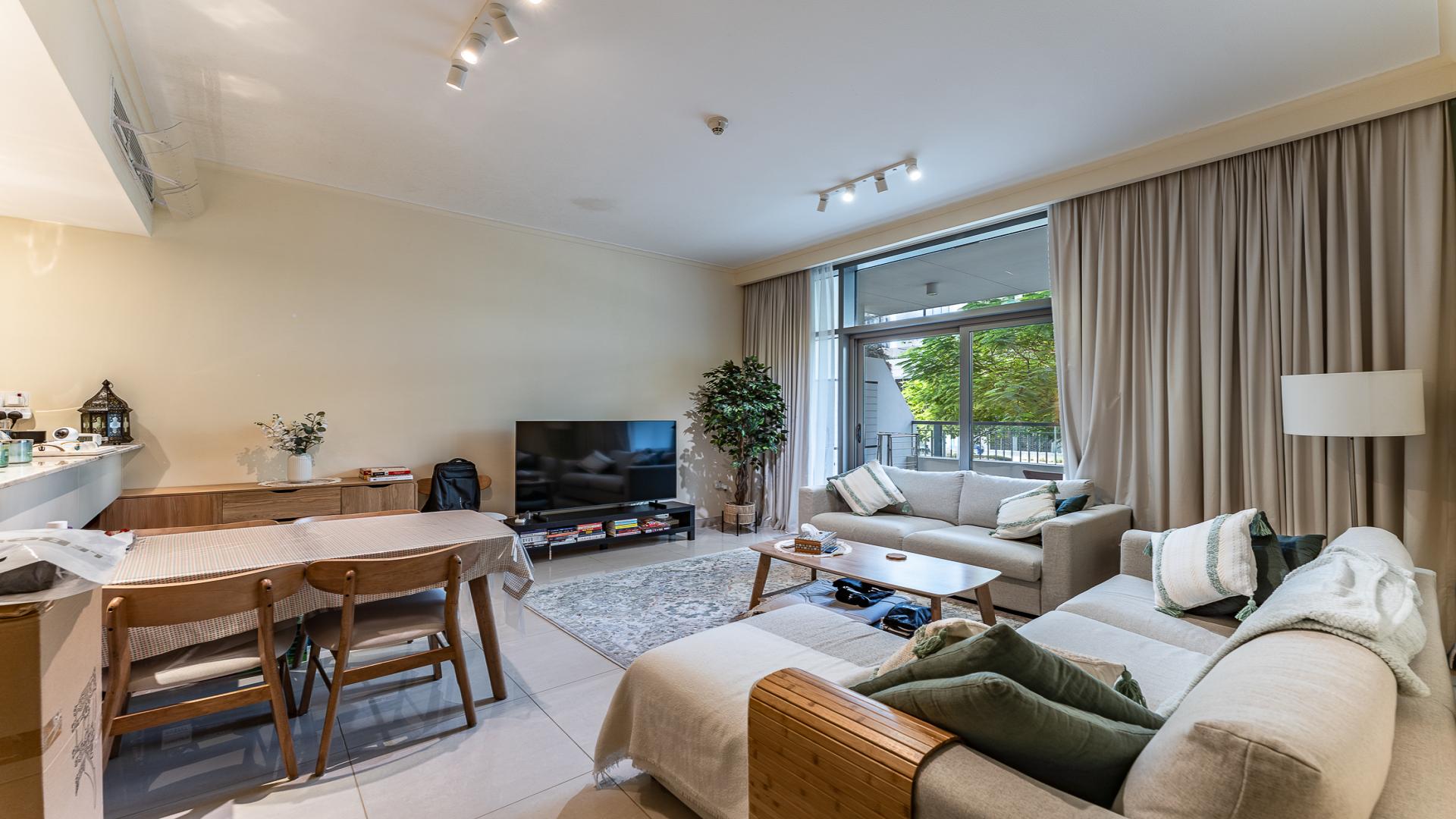 Modern living room in Mulberry apartment, Dubai Hills Estate, with cozy furnishings and natural light