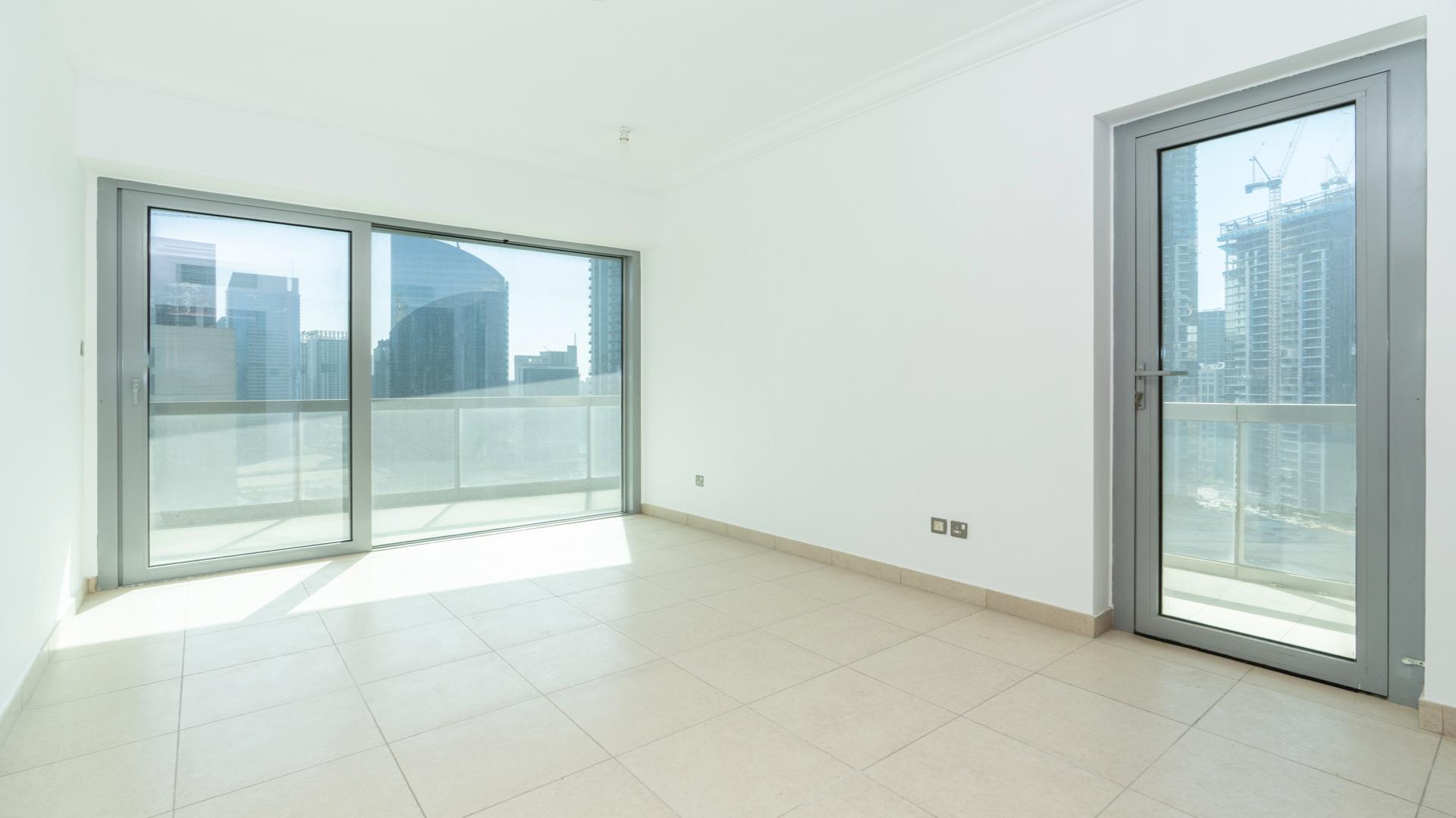 Spacious living area in 8 Boulevard Walk apartment, Downtown Dubai, large windows, tiled floor