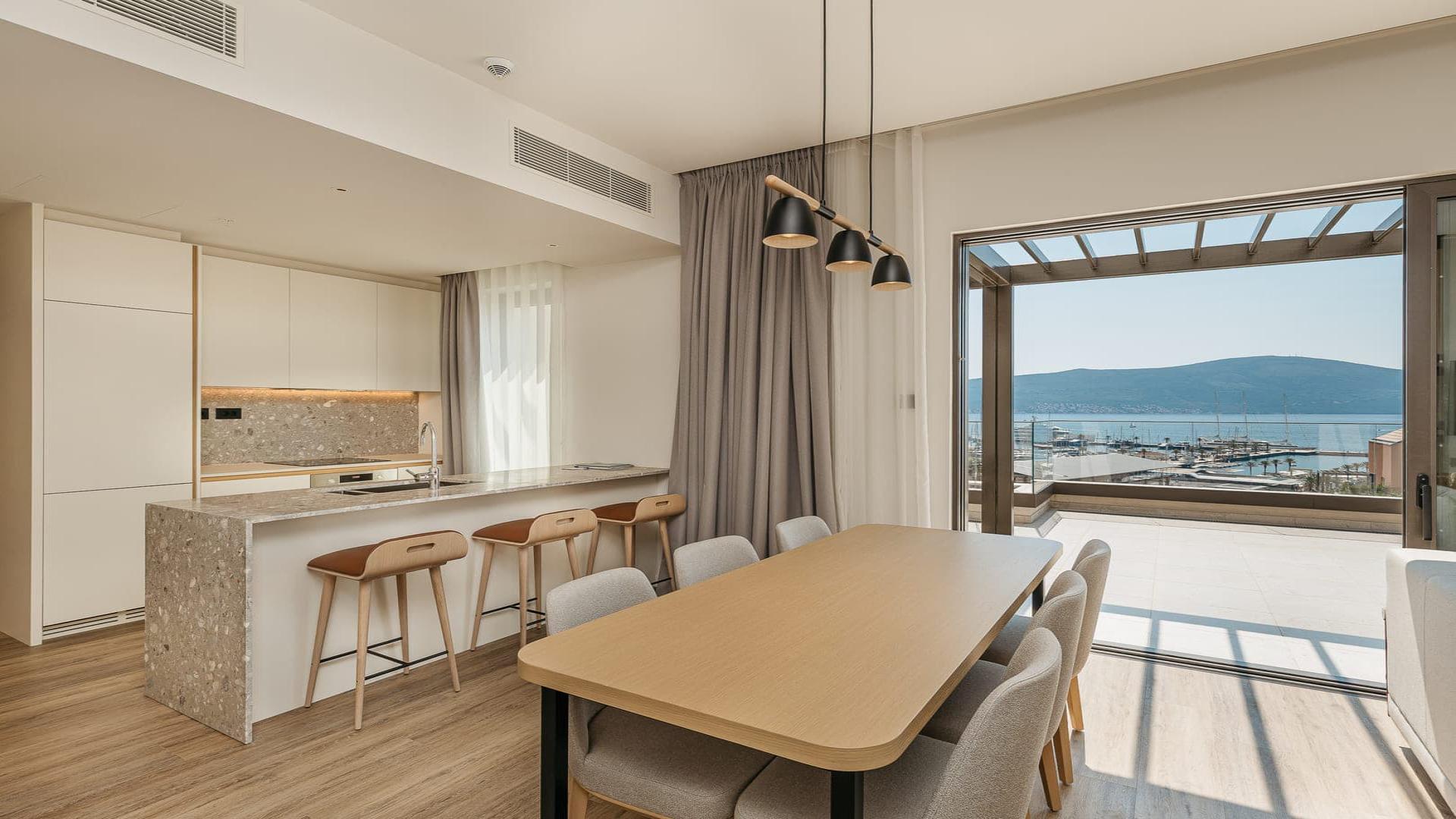 Modern kitchen in Wimbledon Bridge House apartment, featuring sleek design and breakfast bar seating