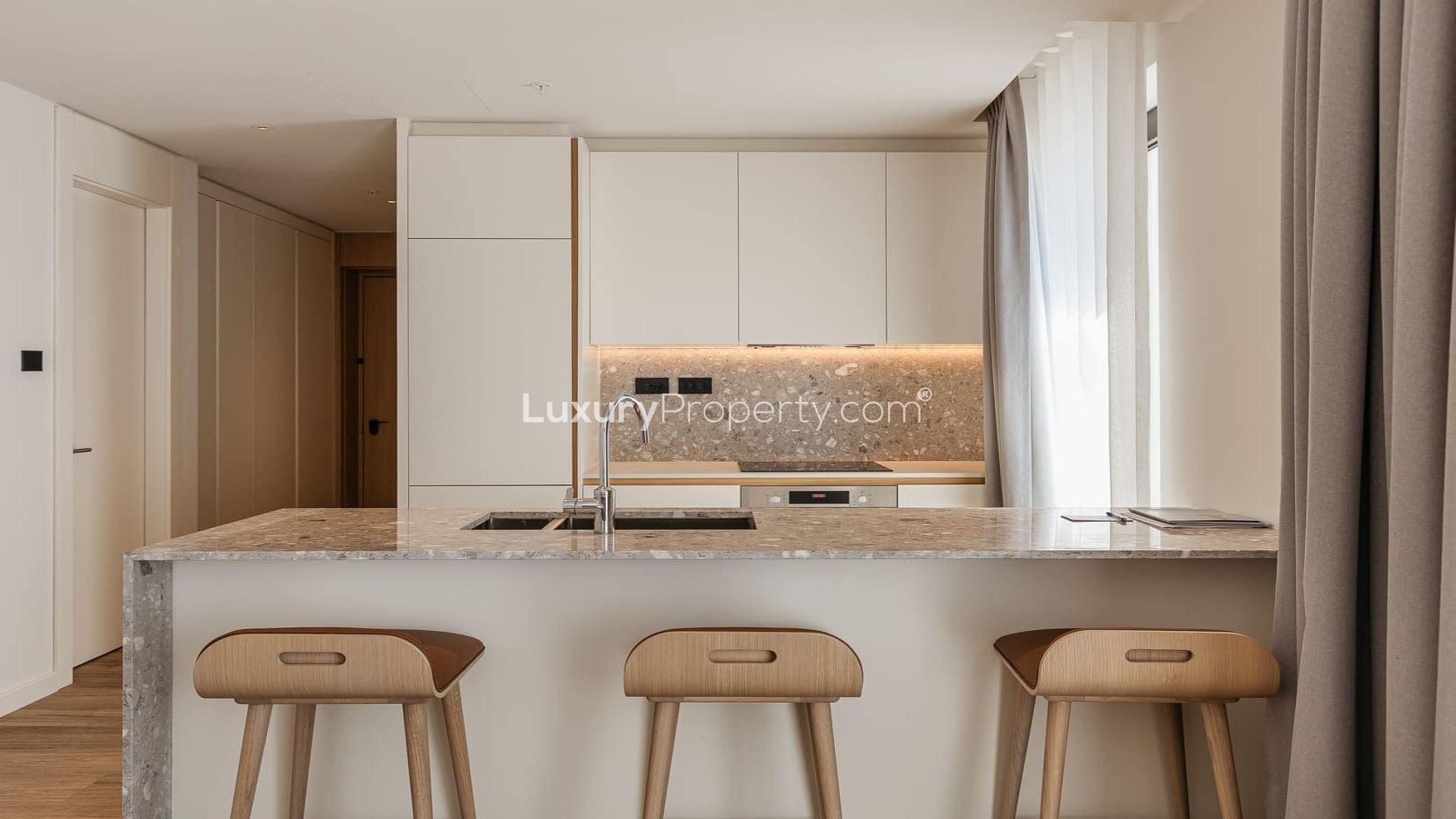 Modern living room in Wimbledon Bridge House Apartment, featuring open-plan kitchen and stylish decor