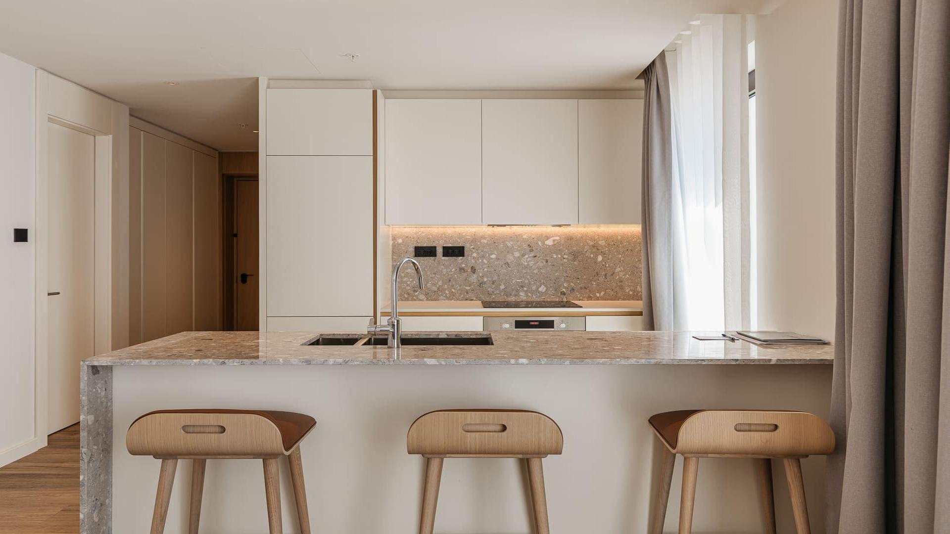 Modern living room in Wimbledon Bridge House Apartment, featuring open-plan kitchen and stylish decor